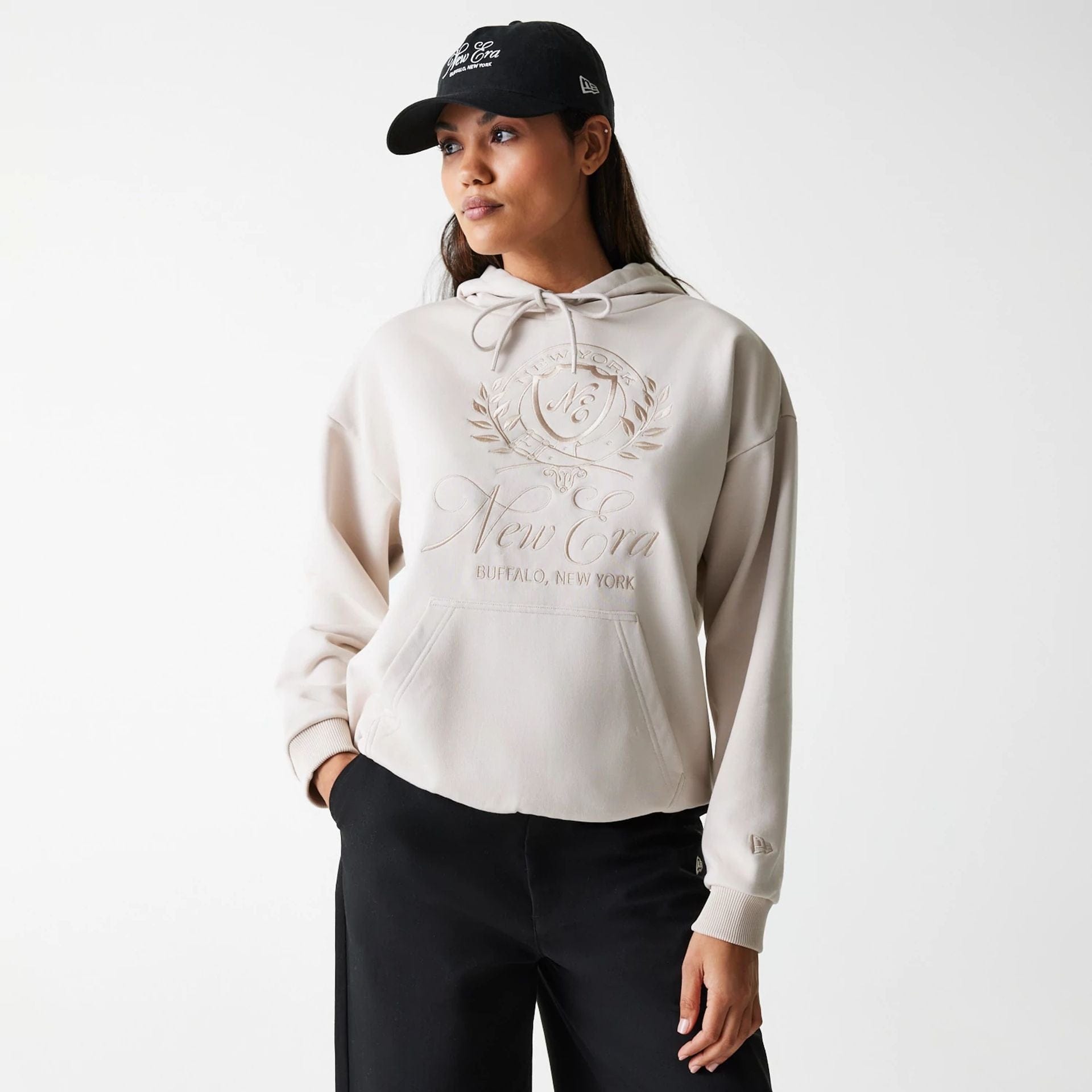 The Female model is wearing Womens New Era Crest Light Beige Pullover Hoodie 1