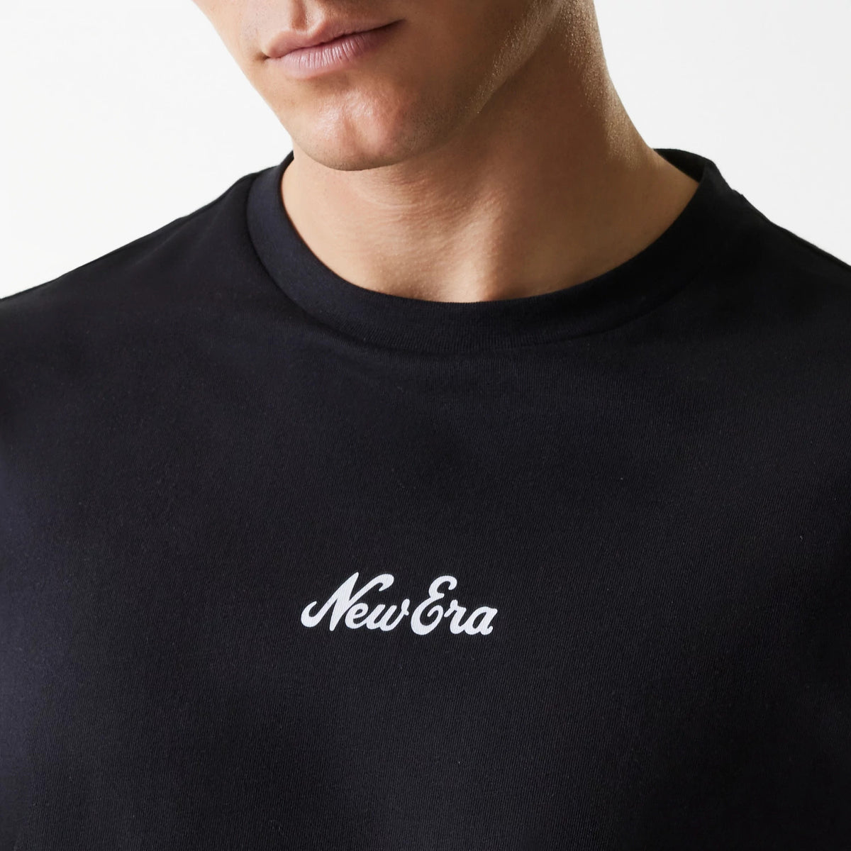 New Era Trucker Patch Black Oversized T-Shirt, front view of a black t-shirt featuring a raised white New Era logo centred on the chest with a round neck visible.