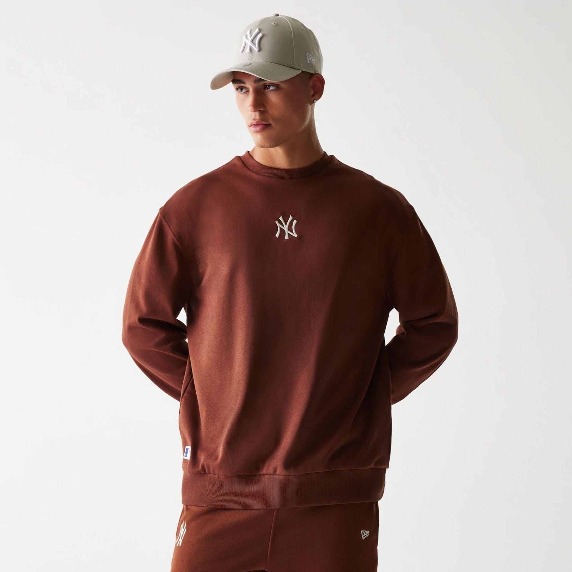 The Male model is wearing New York Yankees MLB Midi League Essential Brown Oversized Crew Neck Sweater 1