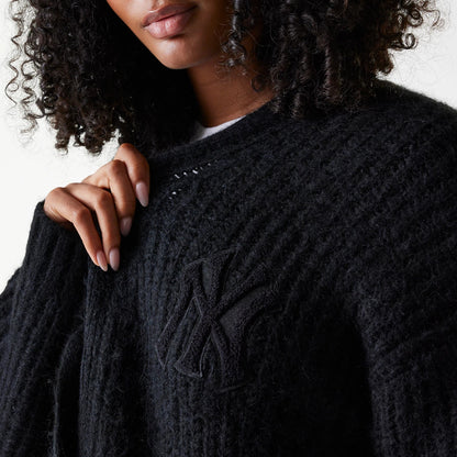 New Era New York Yankees Womens MLB Knit Black Cardigan, close-up on a model showing the textured black knit fabric with embroidered NY logo on the left chest, styled over a white top.