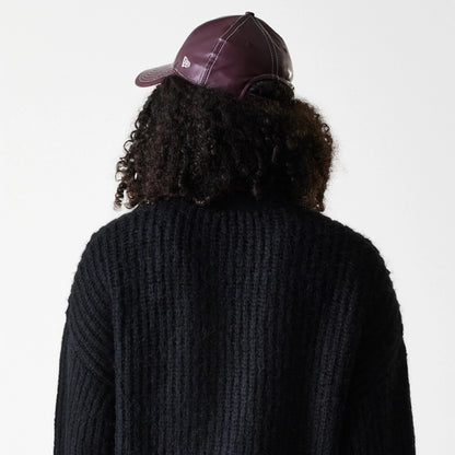 New Era New York Yankees Womens MLB Knit Black Cardigan, rear view on a model with curly hair wearing a black cardigan and a burgundy cap, showcasing the textured knit design and the New Era flag logo on the cap's left side.