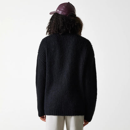 New Era New York Yankees Womens MLB Knit Black Cardigan, back view on a model wearing a burgundy cap, showing the cardigan's textured knit pattern and relaxed fit draping over white trousers.