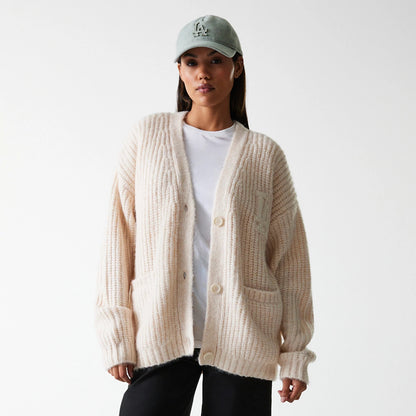 New Era LA Dodgers Womens MLB Knit Light Beige Cardigan, front view on a model with a light blue cap, showing ribbed texture, embroidered LA logo on the upper chest, and large front pockets.
