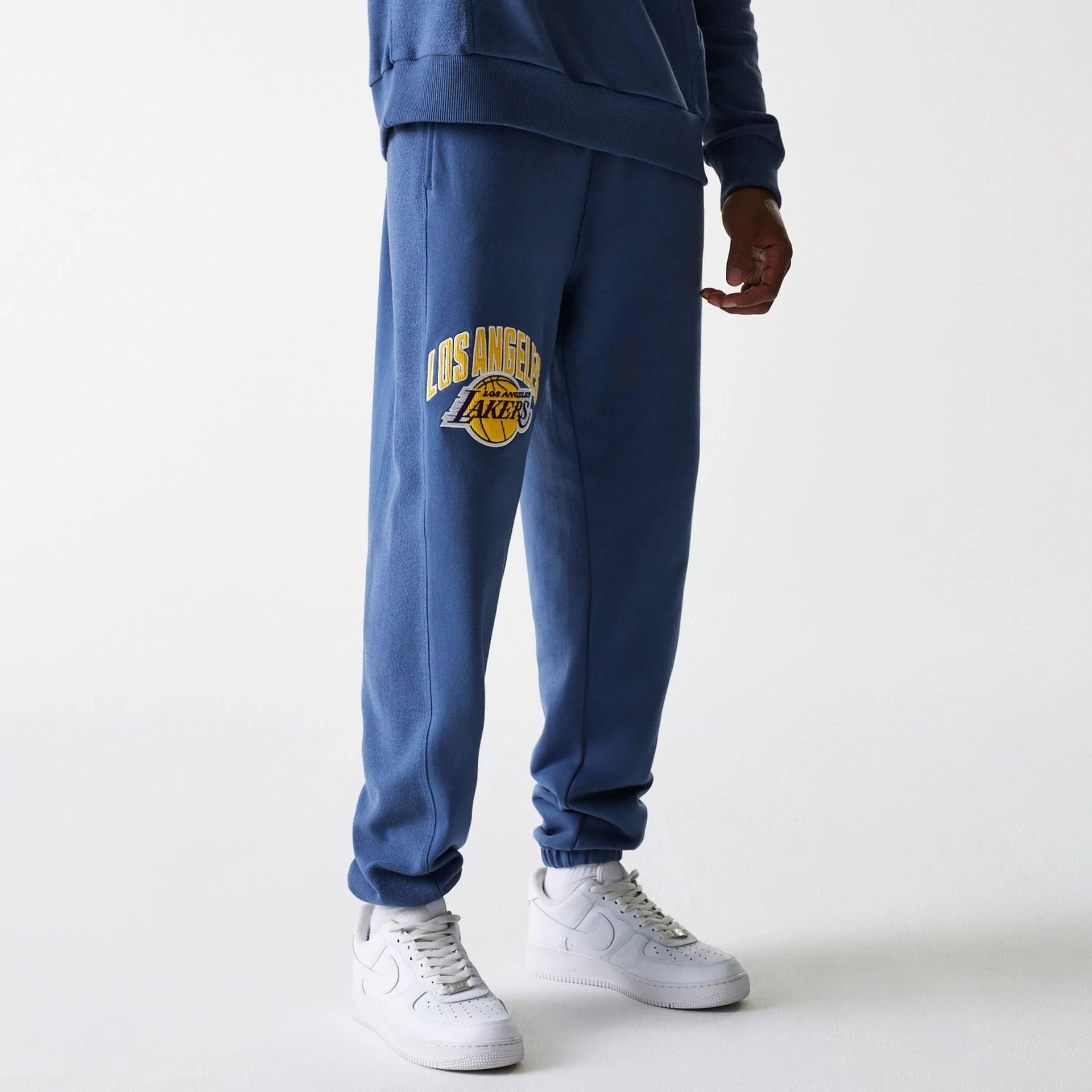 The Male model is wearing LA Lakers NBA Arch Graphic Dark Blue Joggers 5