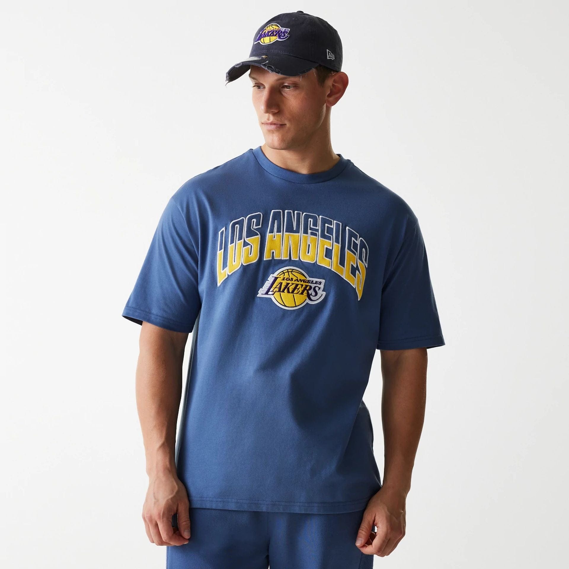 The Male model is wearing LA Lakers NBA Arch Graphic Dark Blue Oversized T-Shirt 3