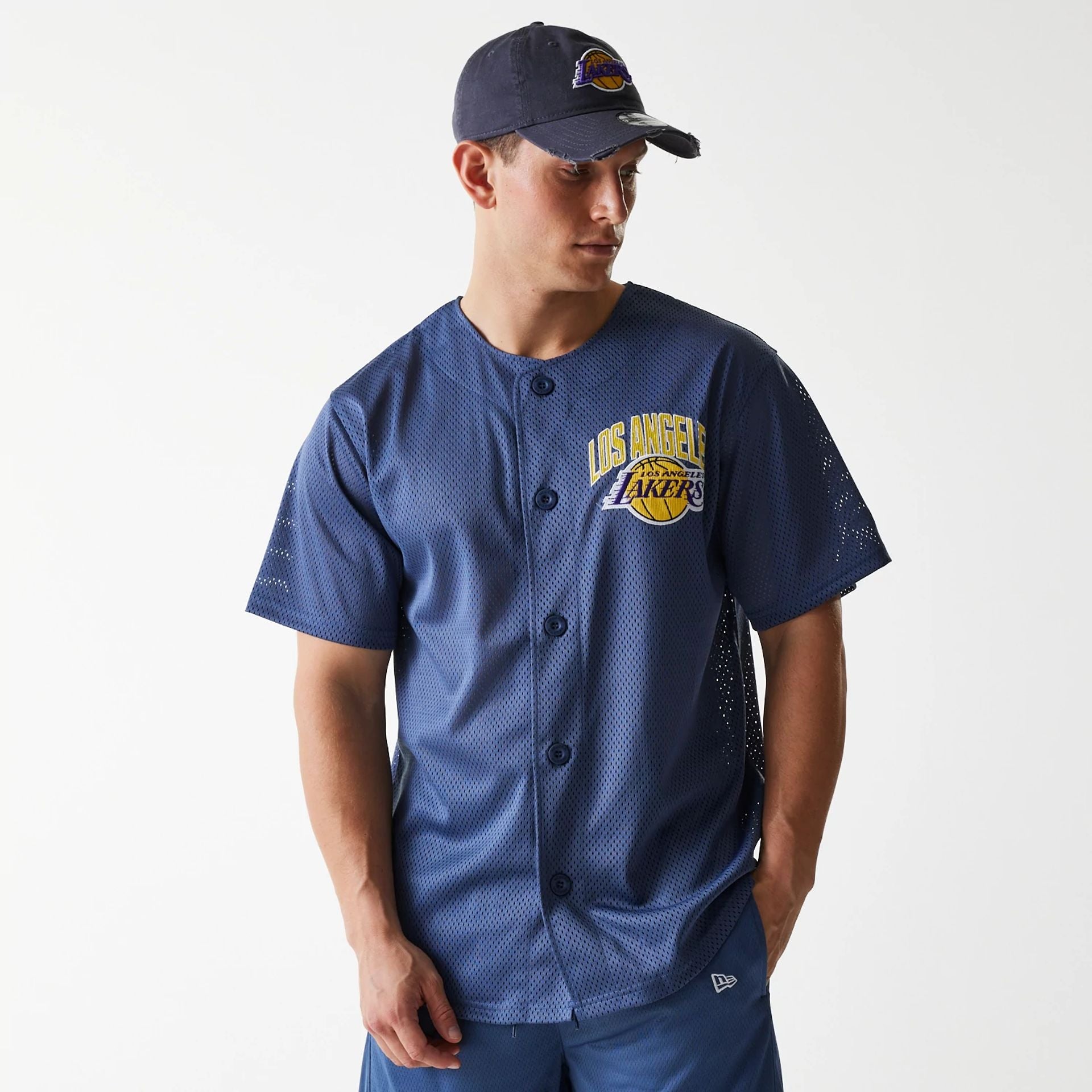 The Male model is wearing LA Lakers NBA Arch Graphic Dark Blue Mesh Jersey 1