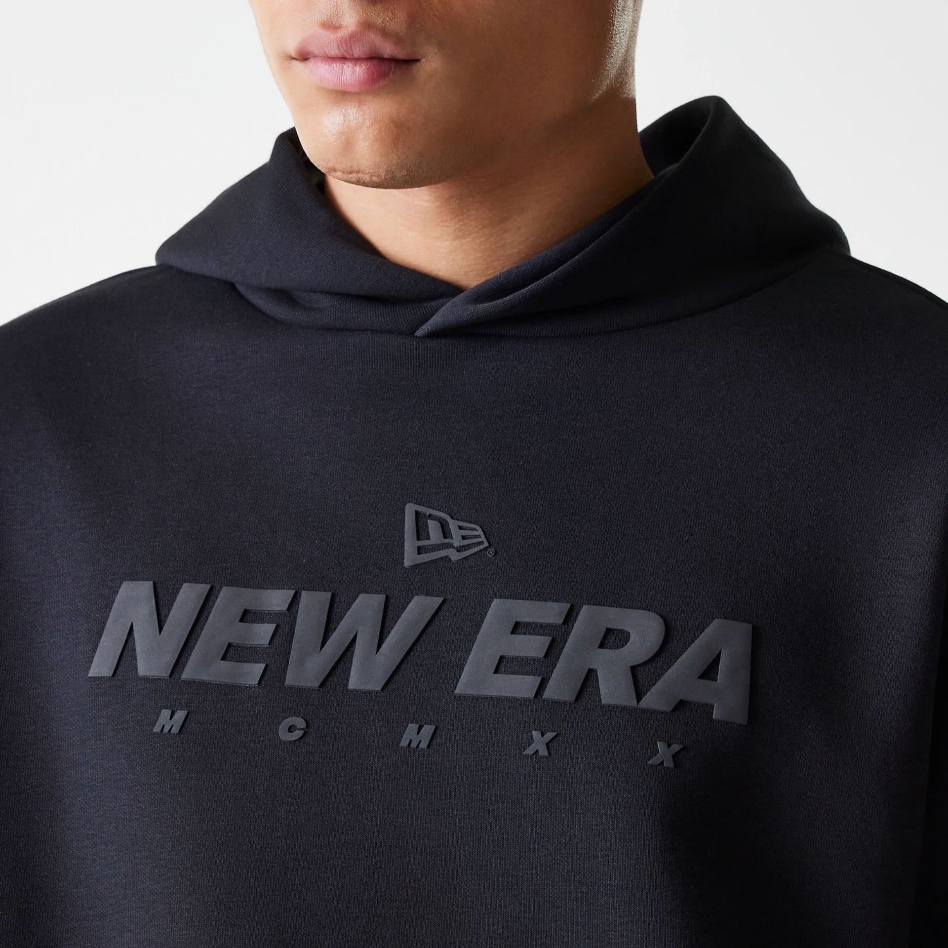 The Male model is wearing New Era Tech Black Oversized Pullover Hoodie 3