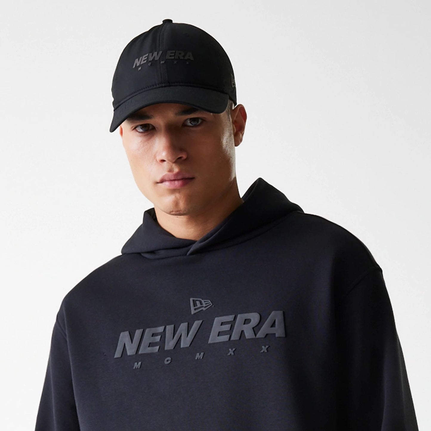 The Male model is wearing New Era Tech Black Oversized Pullover Hoodie 4
