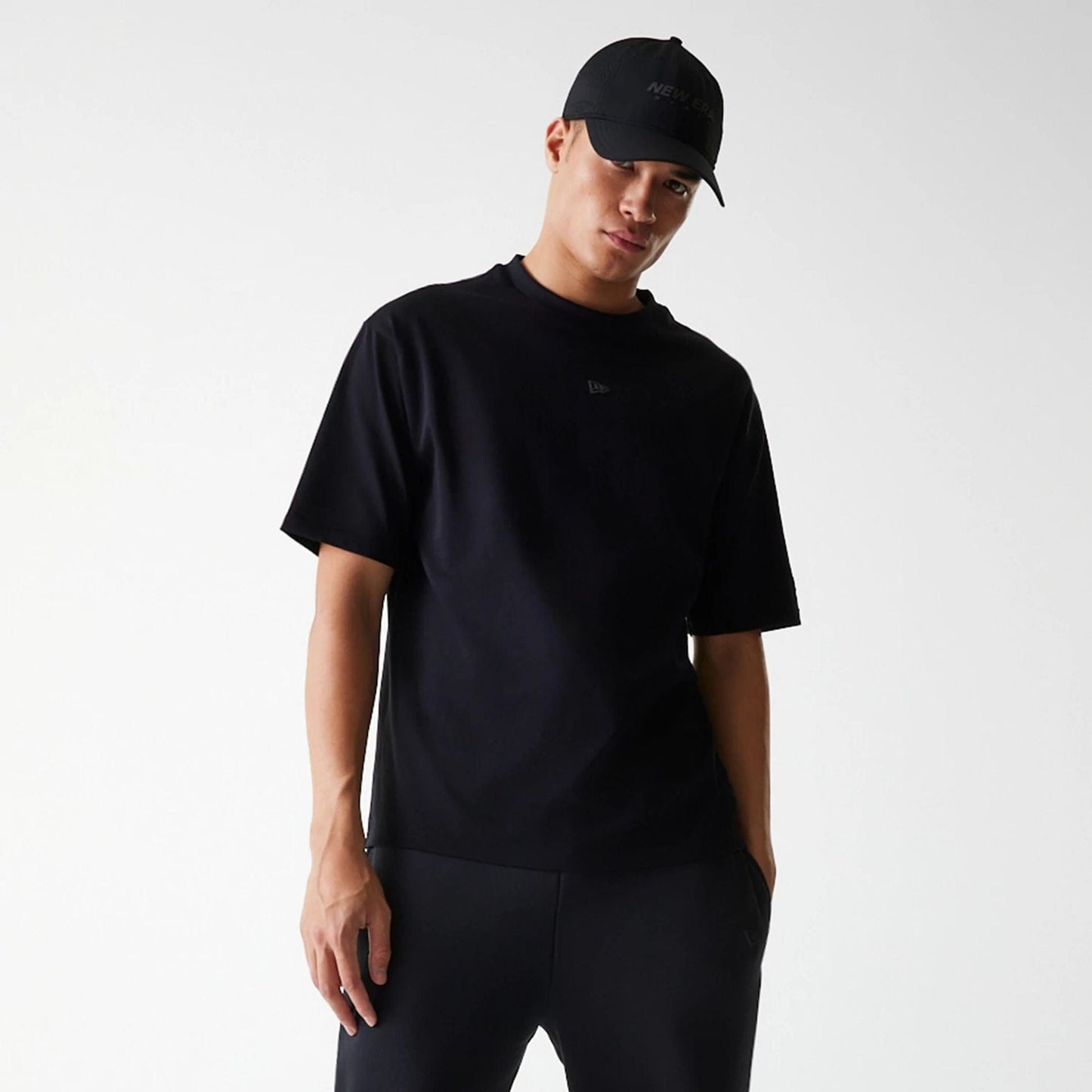 The Male model is wearing New Era Tech Black Oversized T-Shirt 3
