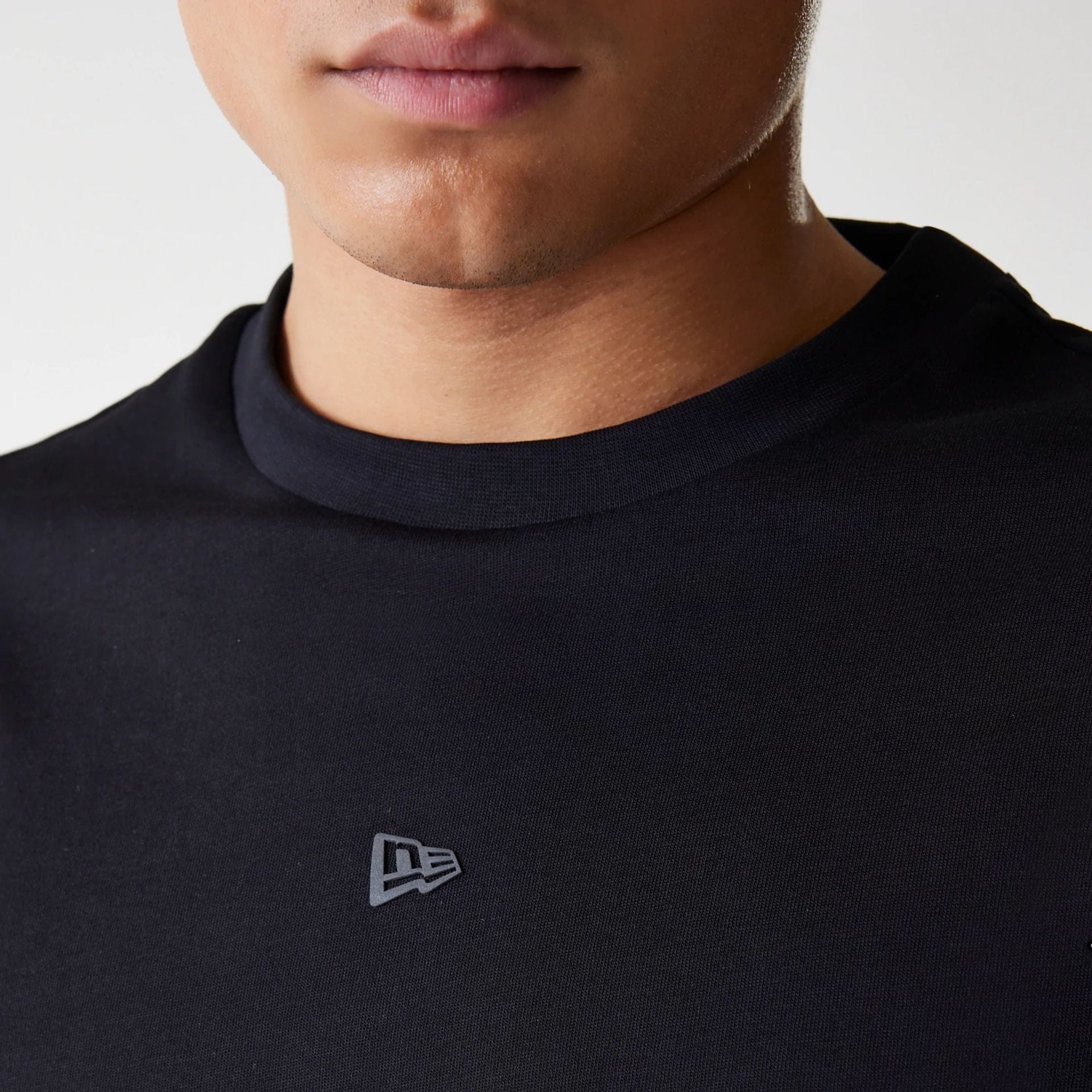 The Male model is wearing New Era Tech Black Oversized T-Shirt 4