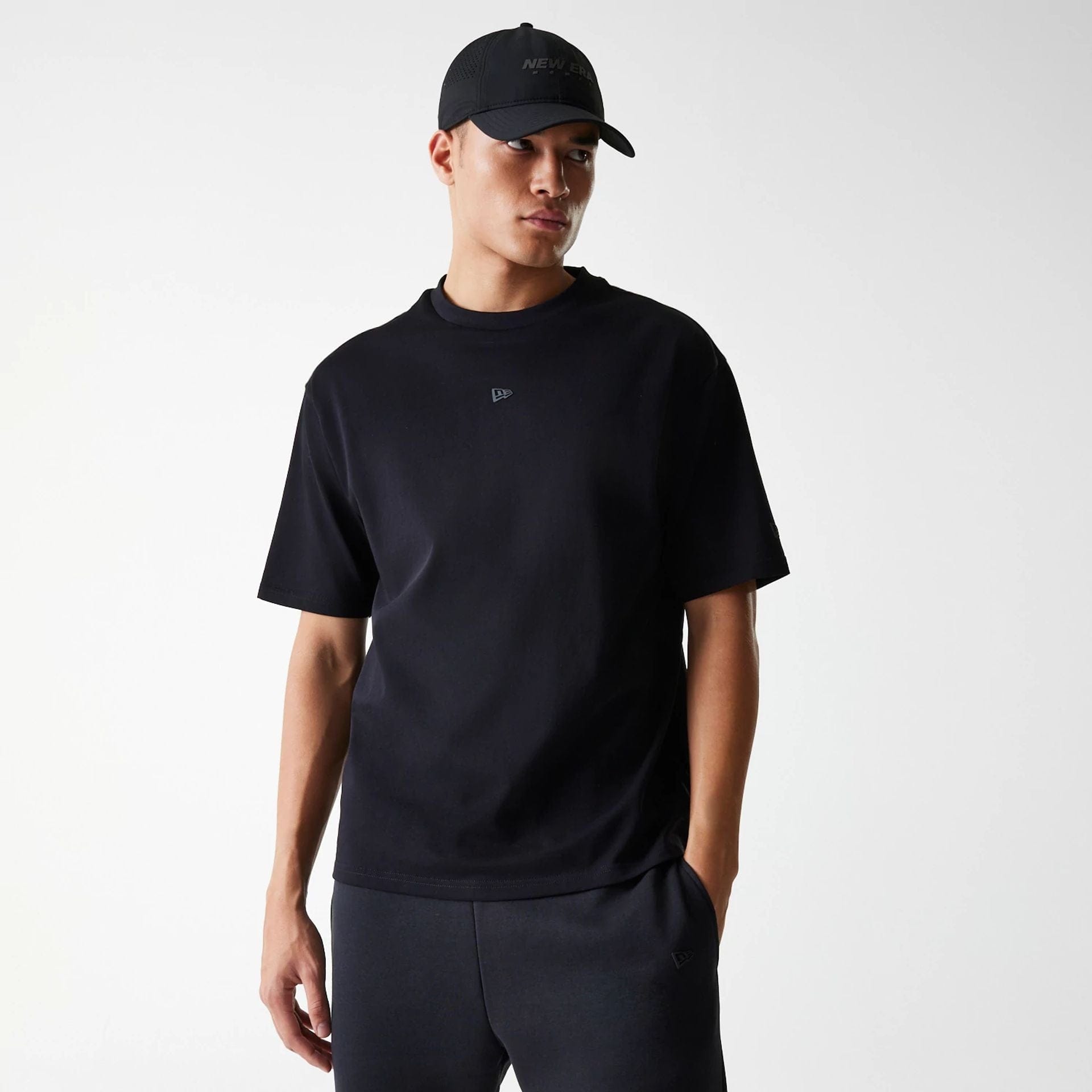 The Male model is wearing New Era Tech Black Oversized T-Shirt 1
