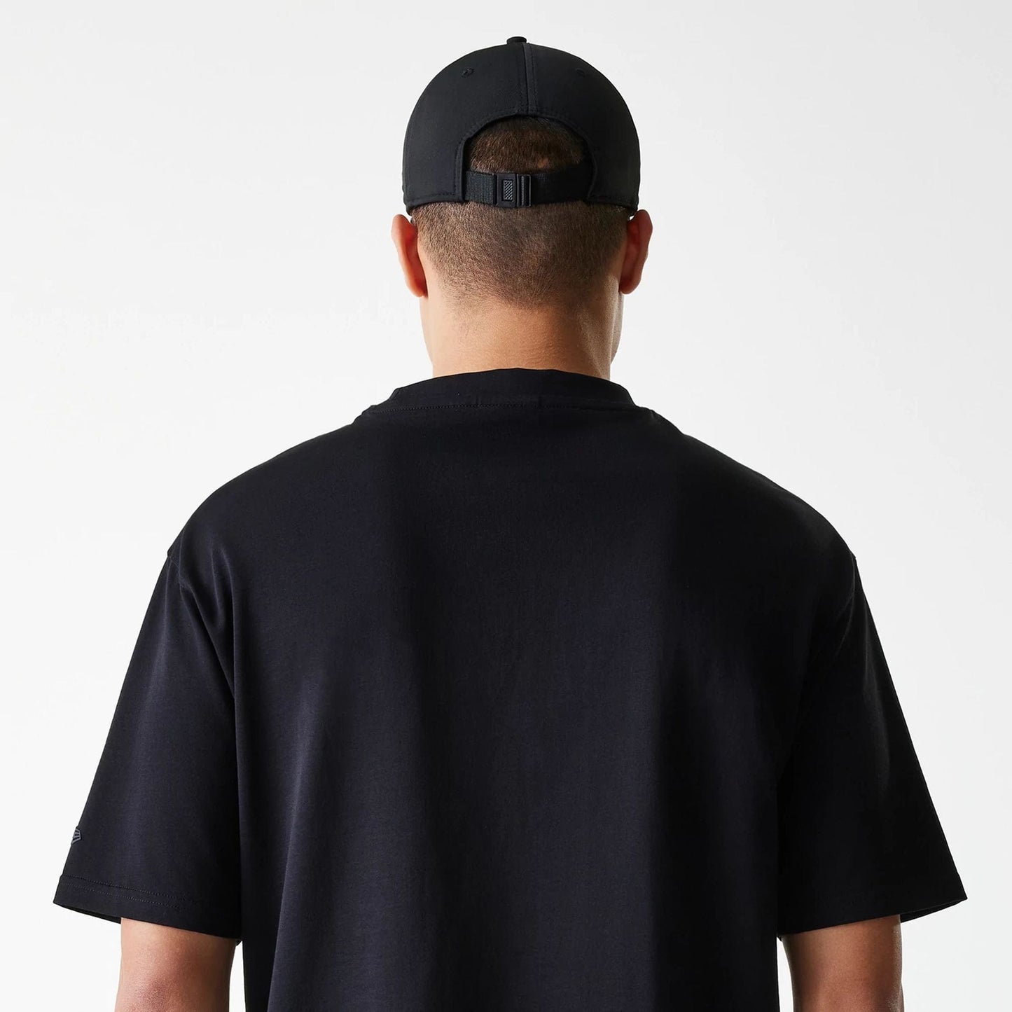 The Male model is wearing New Era Tech Black Oversized T-Shirt 6