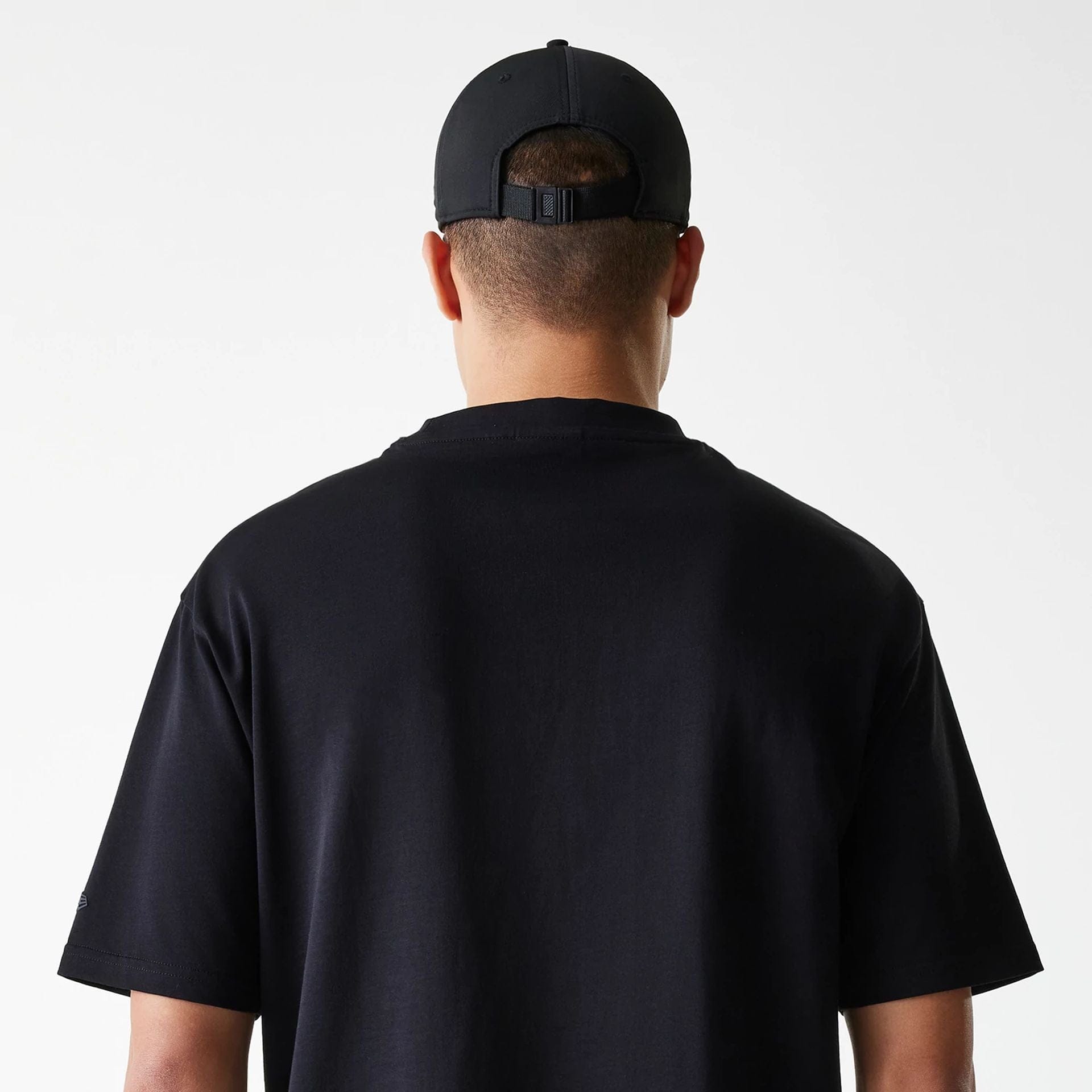 The Male model is wearing New Era Tech Black Oversized T-Shirt 6