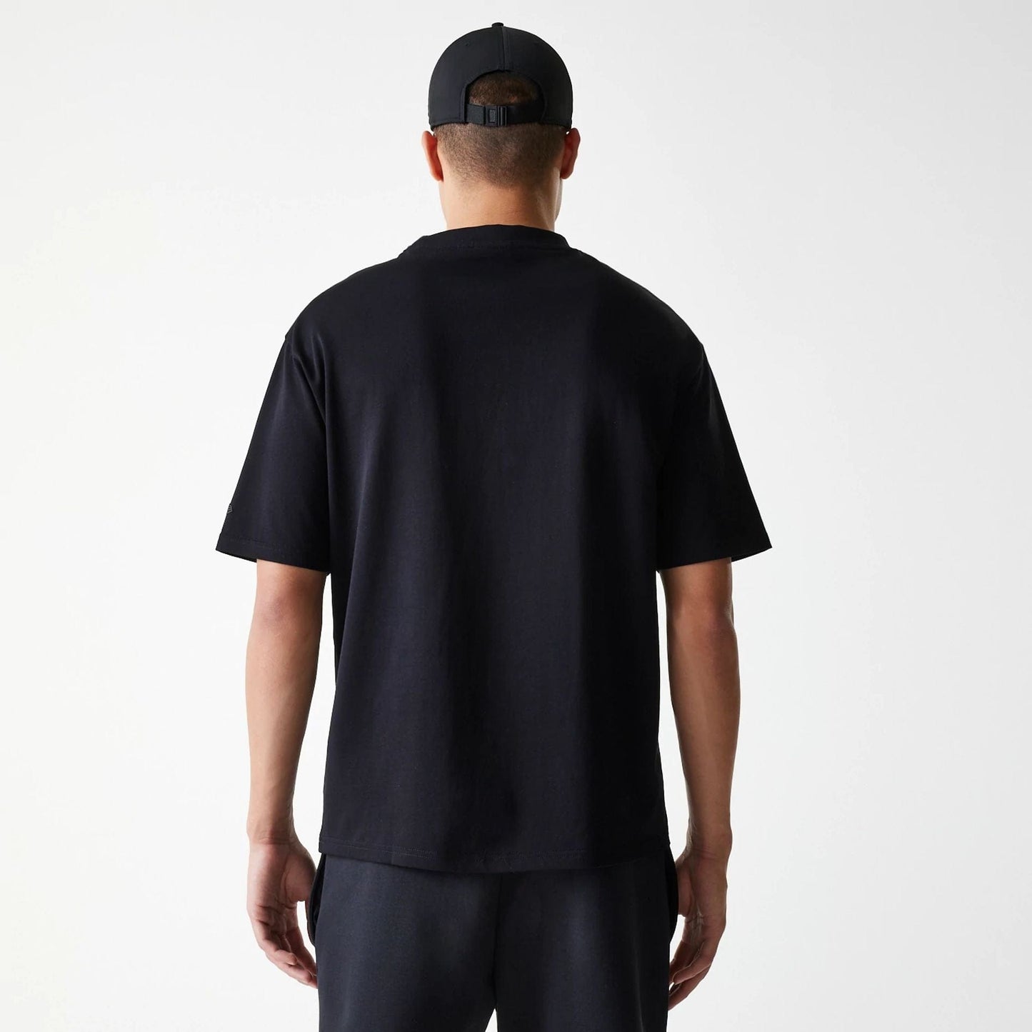 The Male model is wearing New Era Tech Black Oversized T-Shirt 2