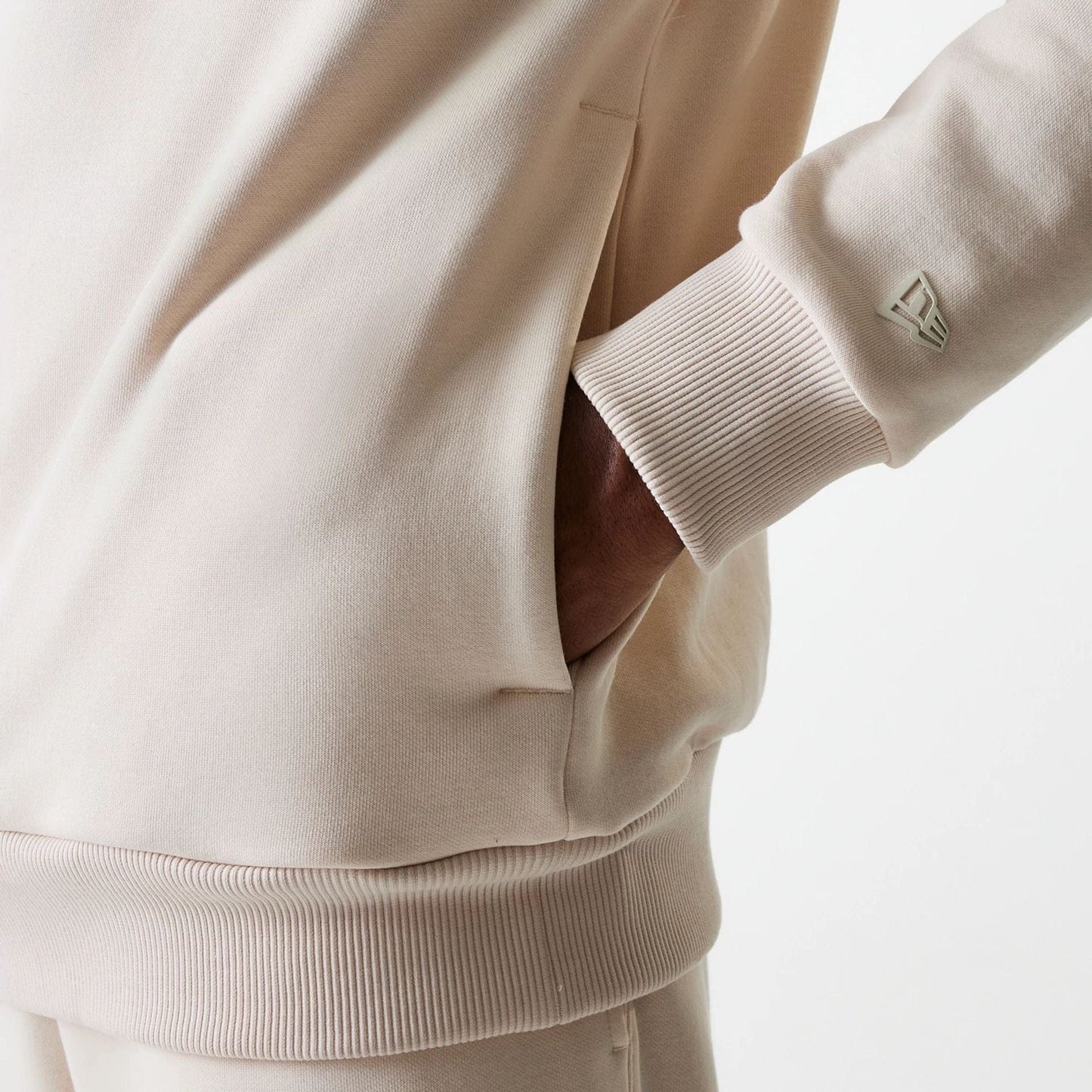 The Male model is wearing New Era Tech Light Beige Oversized Pullover Hoodie 7