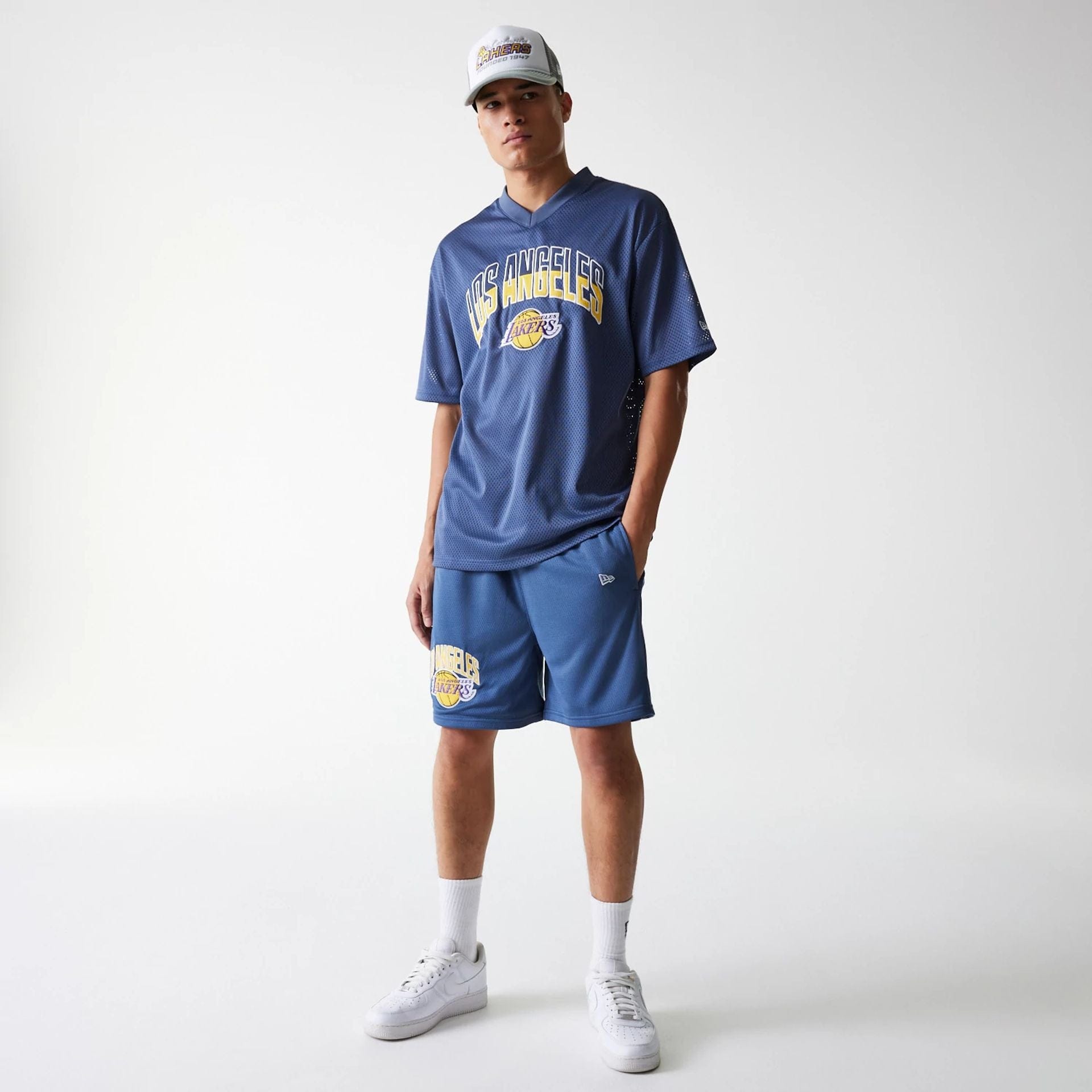 The Male model is wearing LA Lakers NBA Arch Graphic Dark Blue Mesh Shorts 8