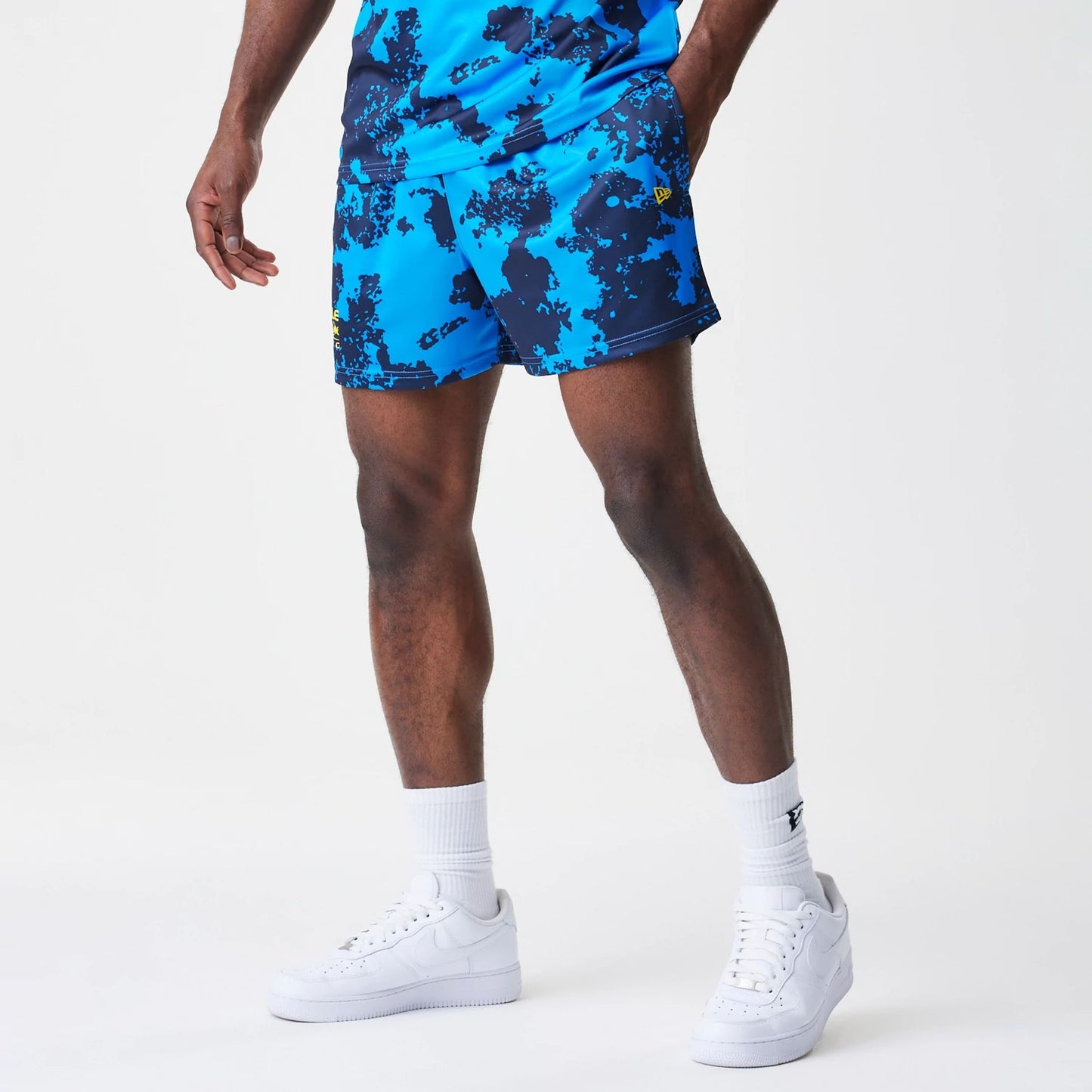 The Male model is wearing Red Bull Racing Graphic Blue Football Shorts 1