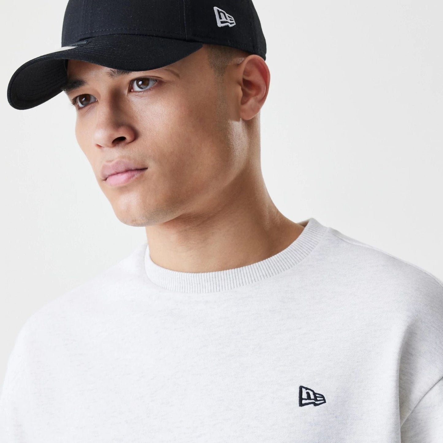 The Male model is wearing New Era Premium Essential Pastel Grey Oversized Crew Neck Sweater 4