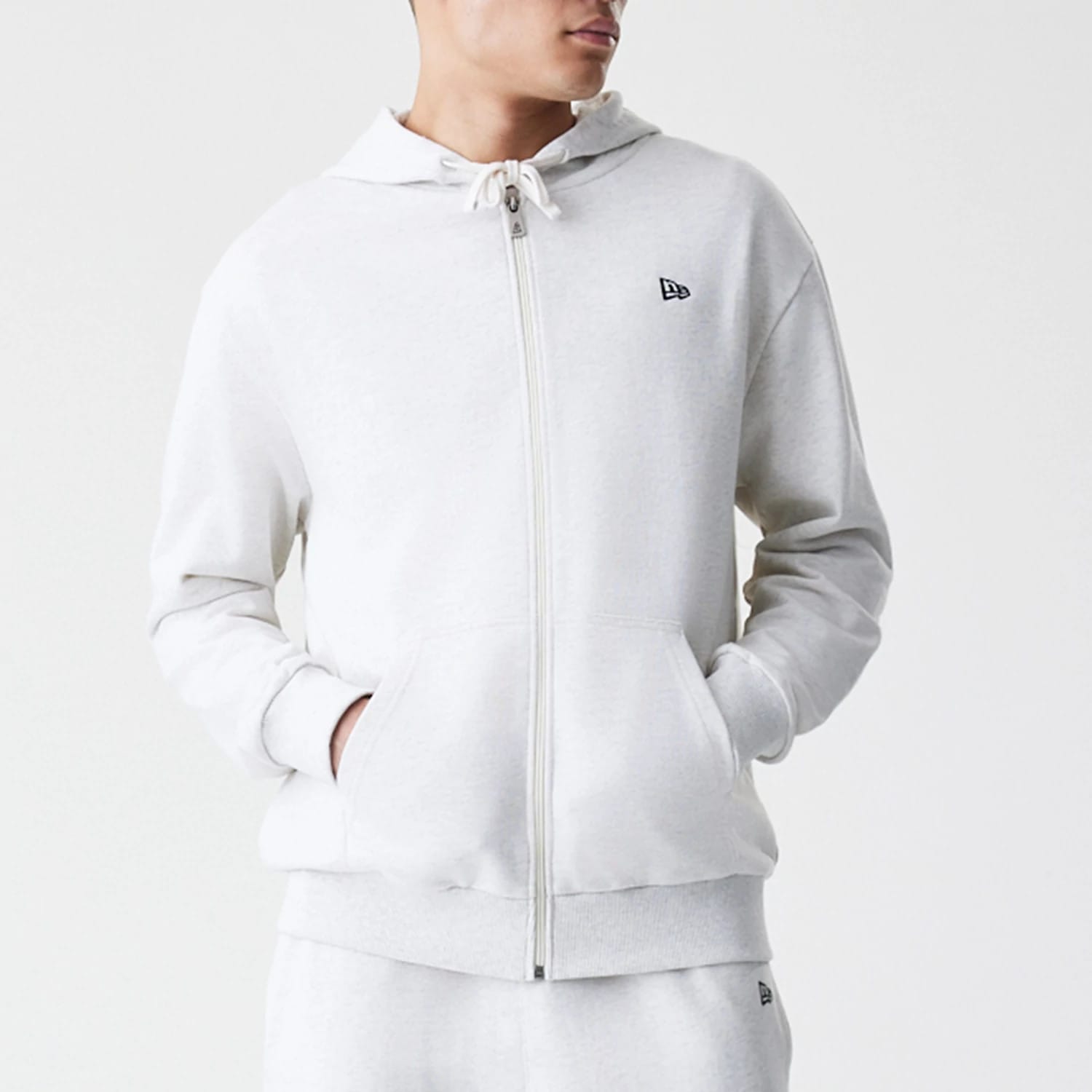 The Male model is wearing New Era Premium Essential Pastel Grey Oversized Full Zip Hoodie 3