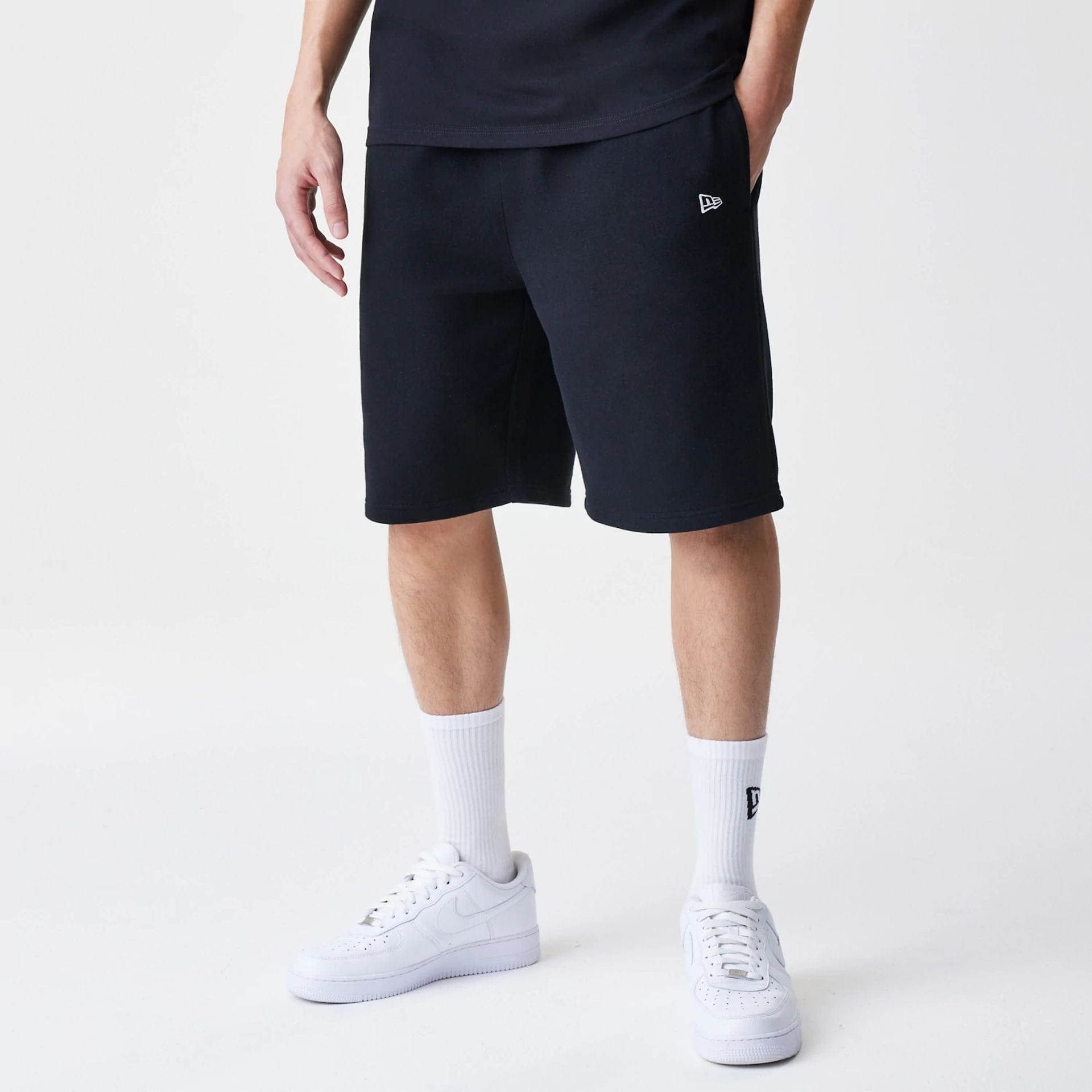 The Male model is wearing New Era Premium Essential Black Oversized Shorts 1