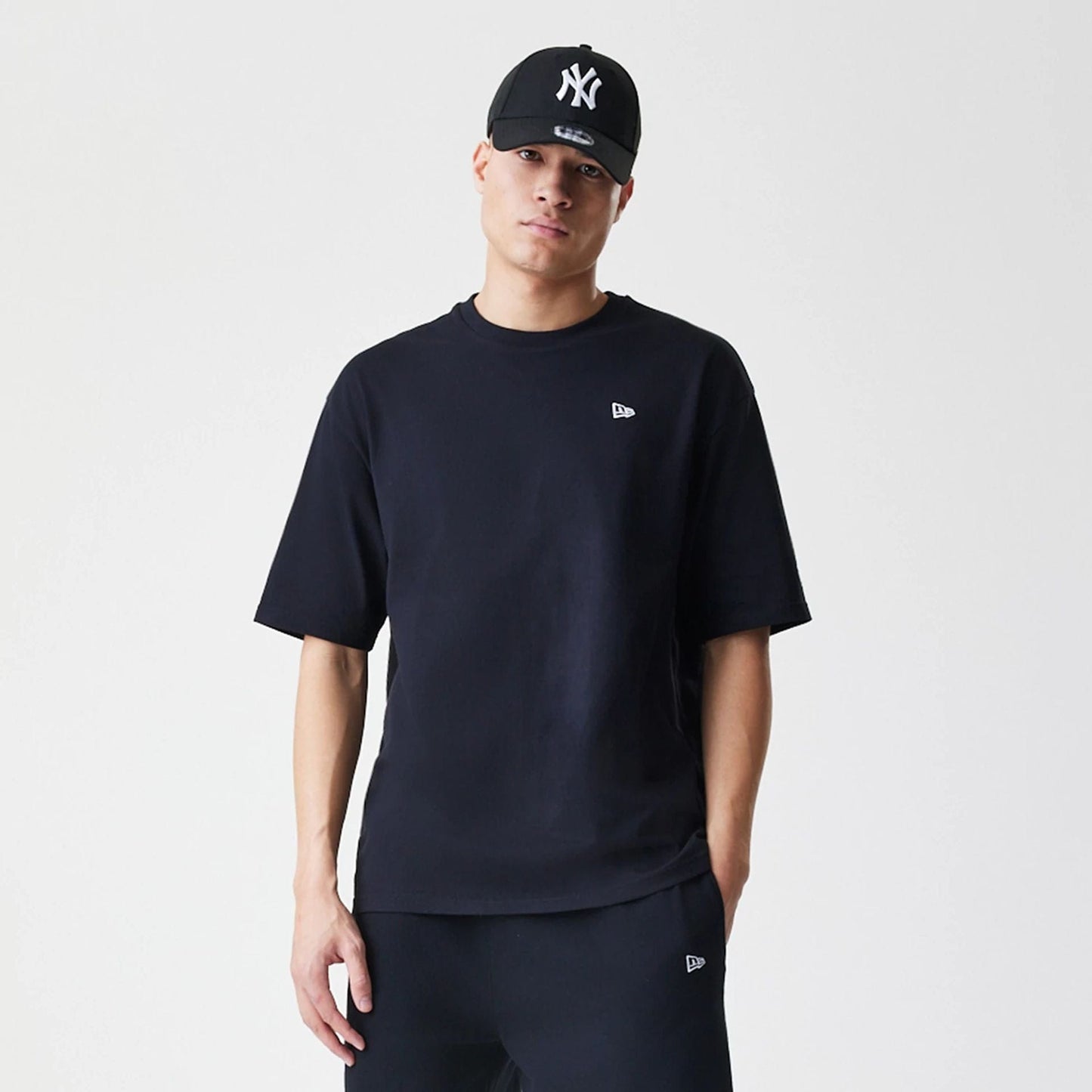 The Male model is wearing New Era Premium Essential Black Oversized T-Shirt 3