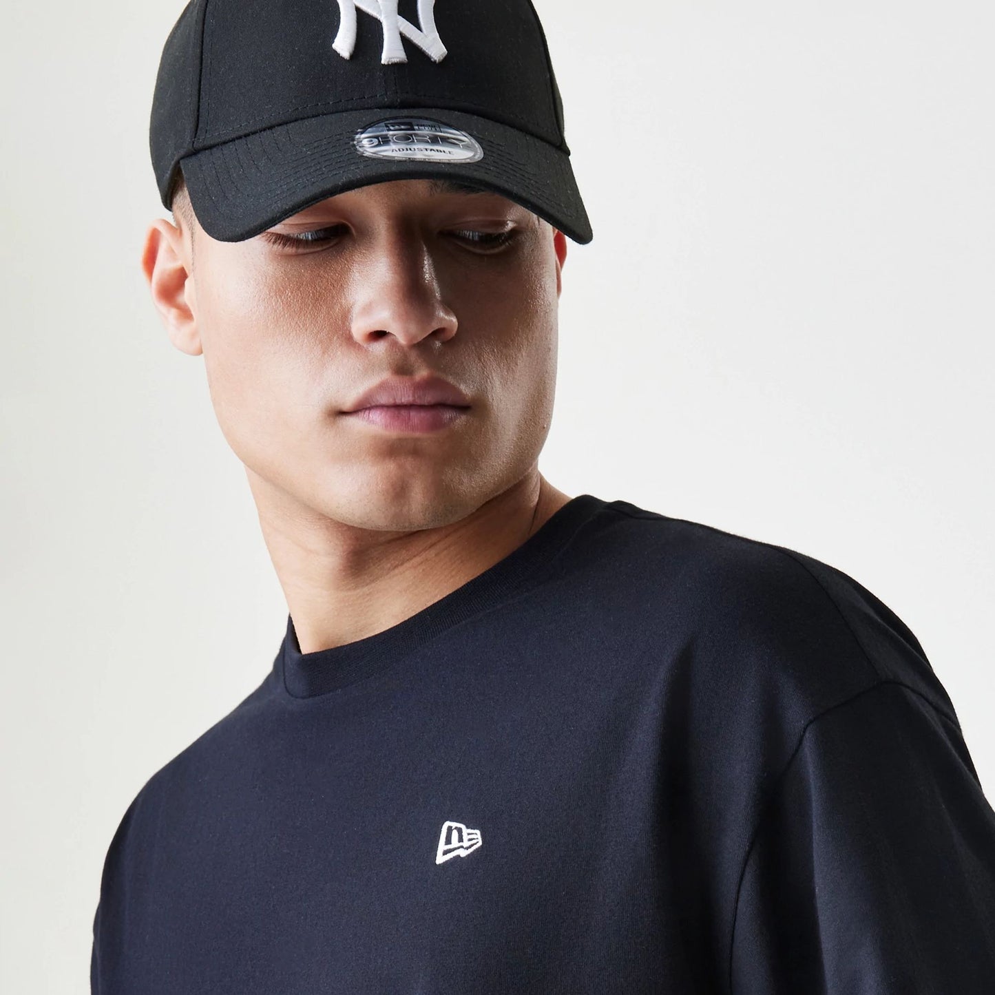 The Male model is wearing New Era Premium Essential Black Oversized T-Shirt 4