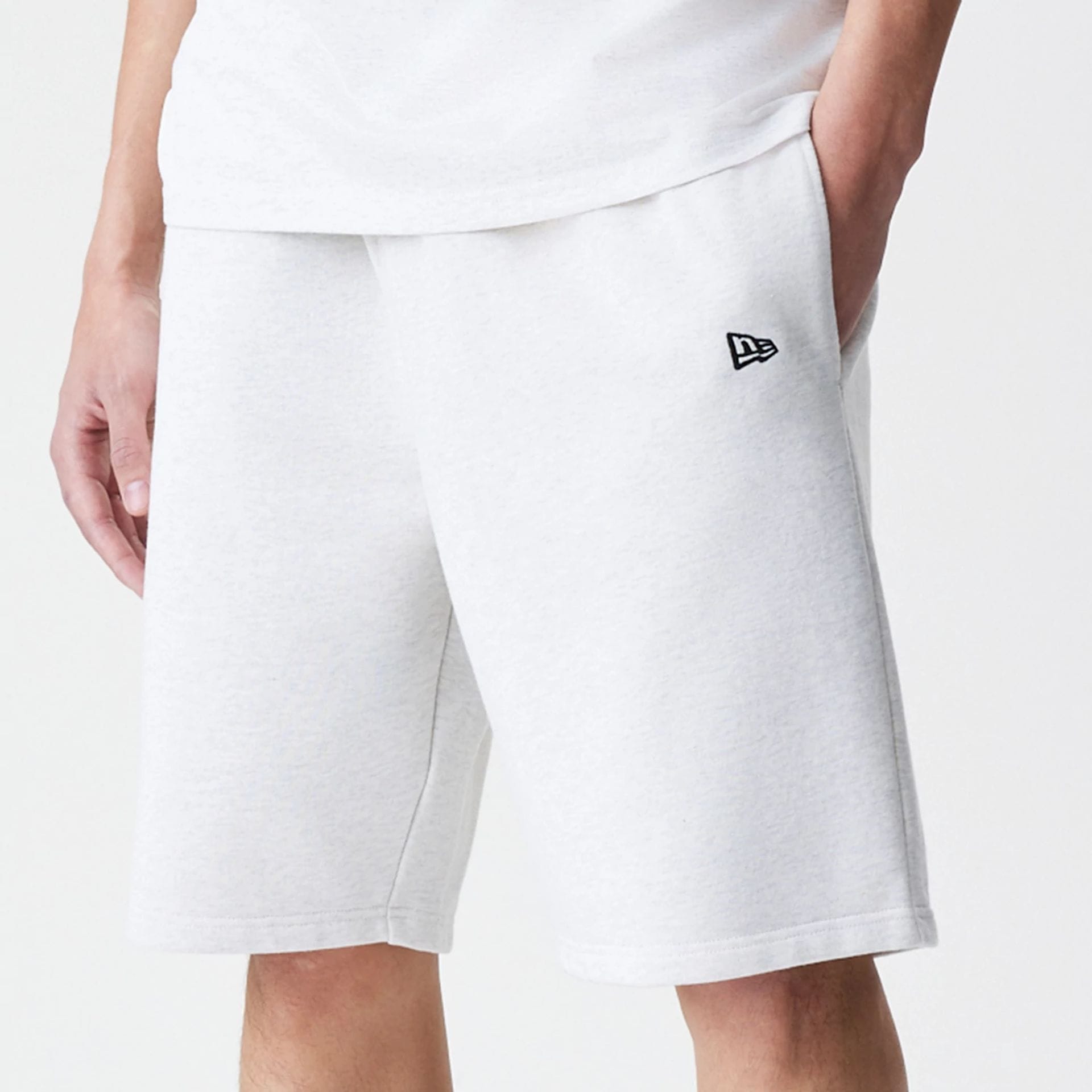 The Male model is wearing New Era Premium Essential Pastel Grey Oversized Shorts 4