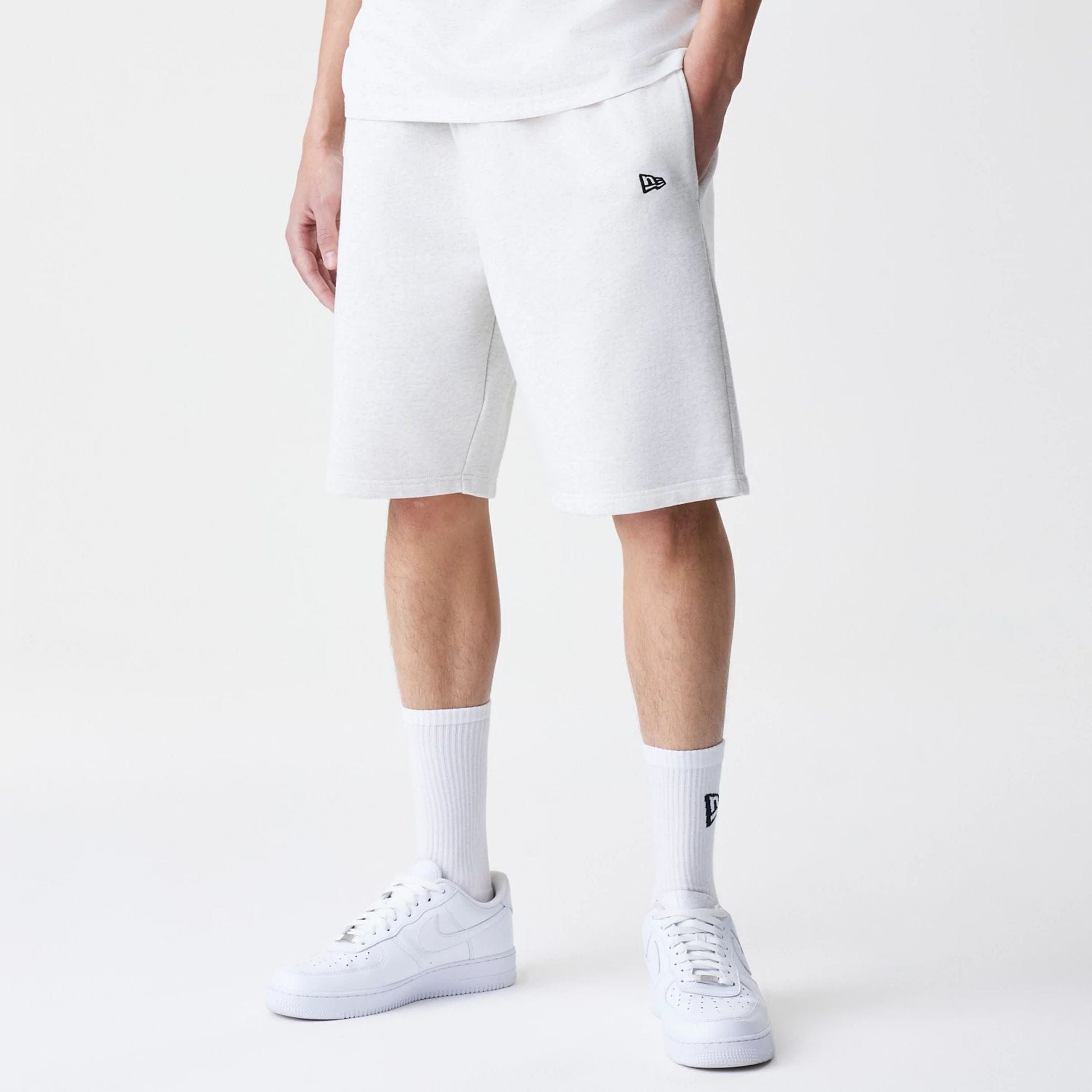 The Male model is wearing New Era Premium Essential Pastel Grey Oversized Shorts 1