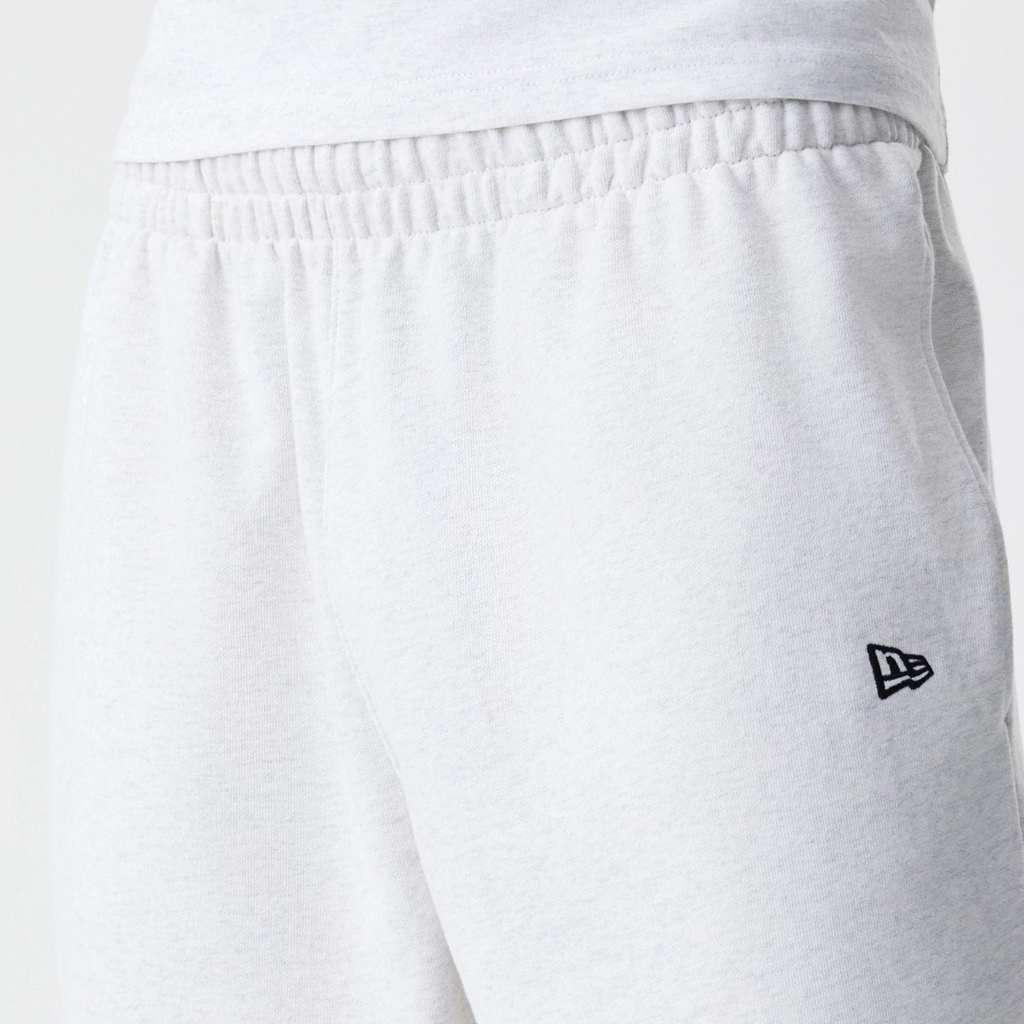 The Male model is wearing New Era Premium Essential Pastel Grey Oversized Shorts 6