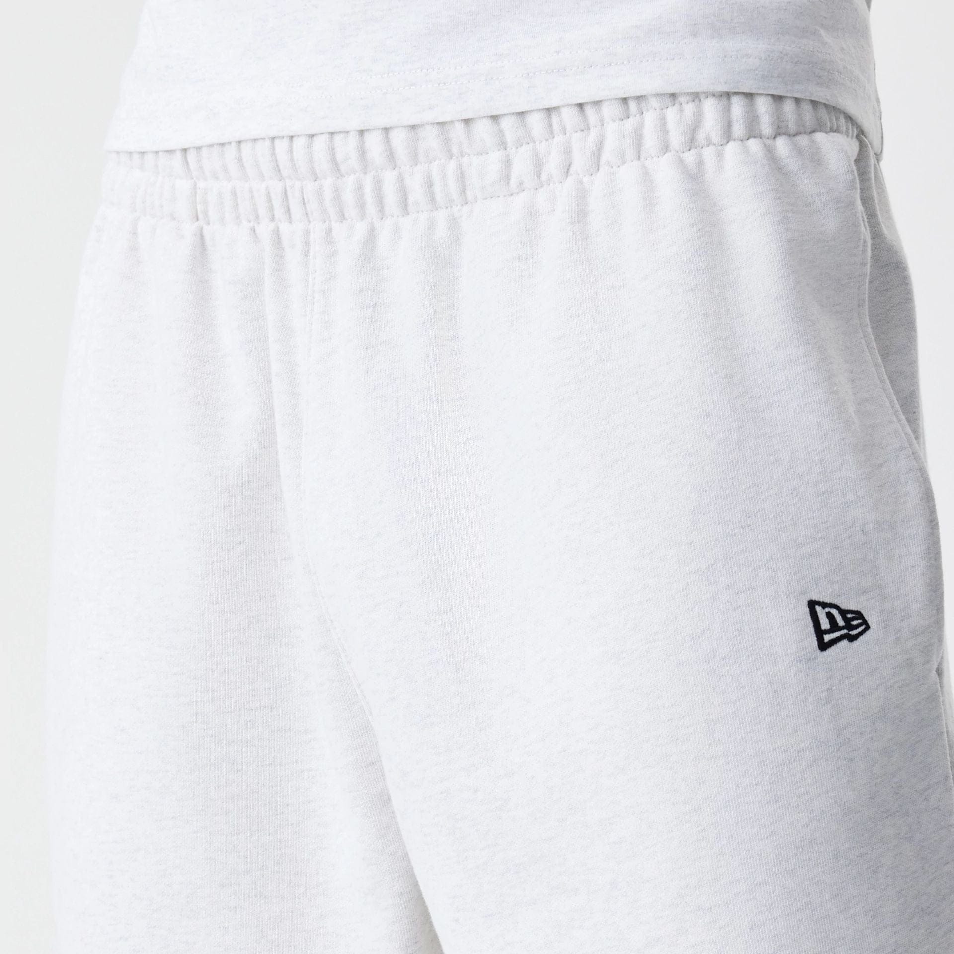 The Male model is wearing New Era Premium Essential Pastel Grey Oversized Shorts 6