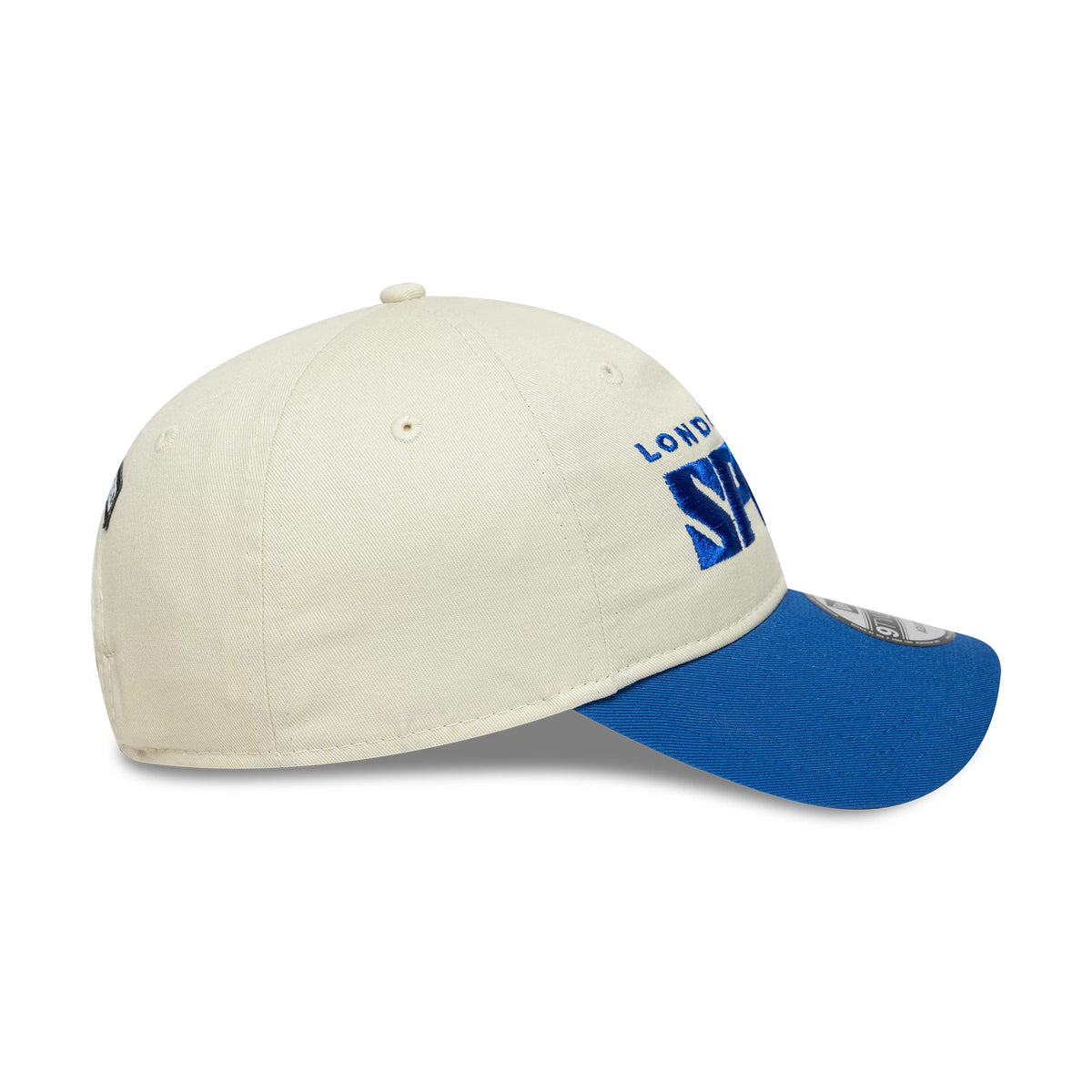 London Spirit The Hundred 2025 Contrast Light Beige New Era 9TWENTY Adjustable Cap, side view showing the blue embroidered Spirit logo on the front panel, blue curved visor, beige crown with matching top button and eyelets on all panels.