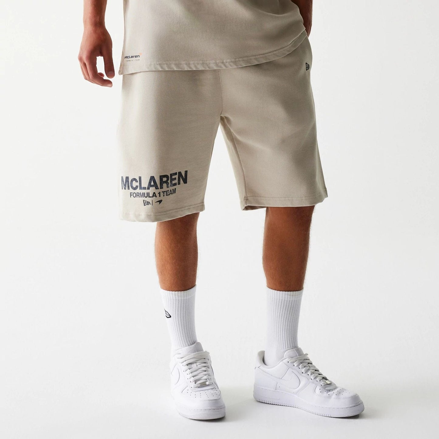The Male model is wearing McLaren Racing Wordmark Light Beige Oversized Shorts 1