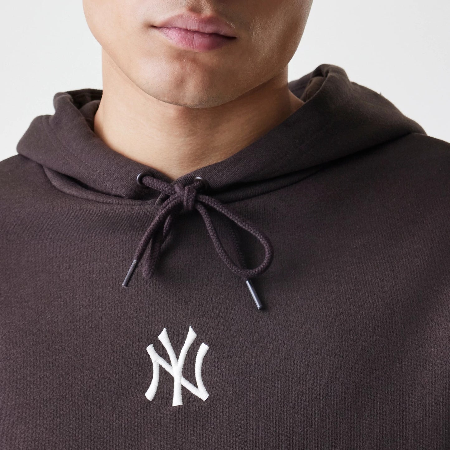 The Male model is wearing New York Yankees MLB Midi League Essential Dark Brown Oversized Pullover Hoodie 3