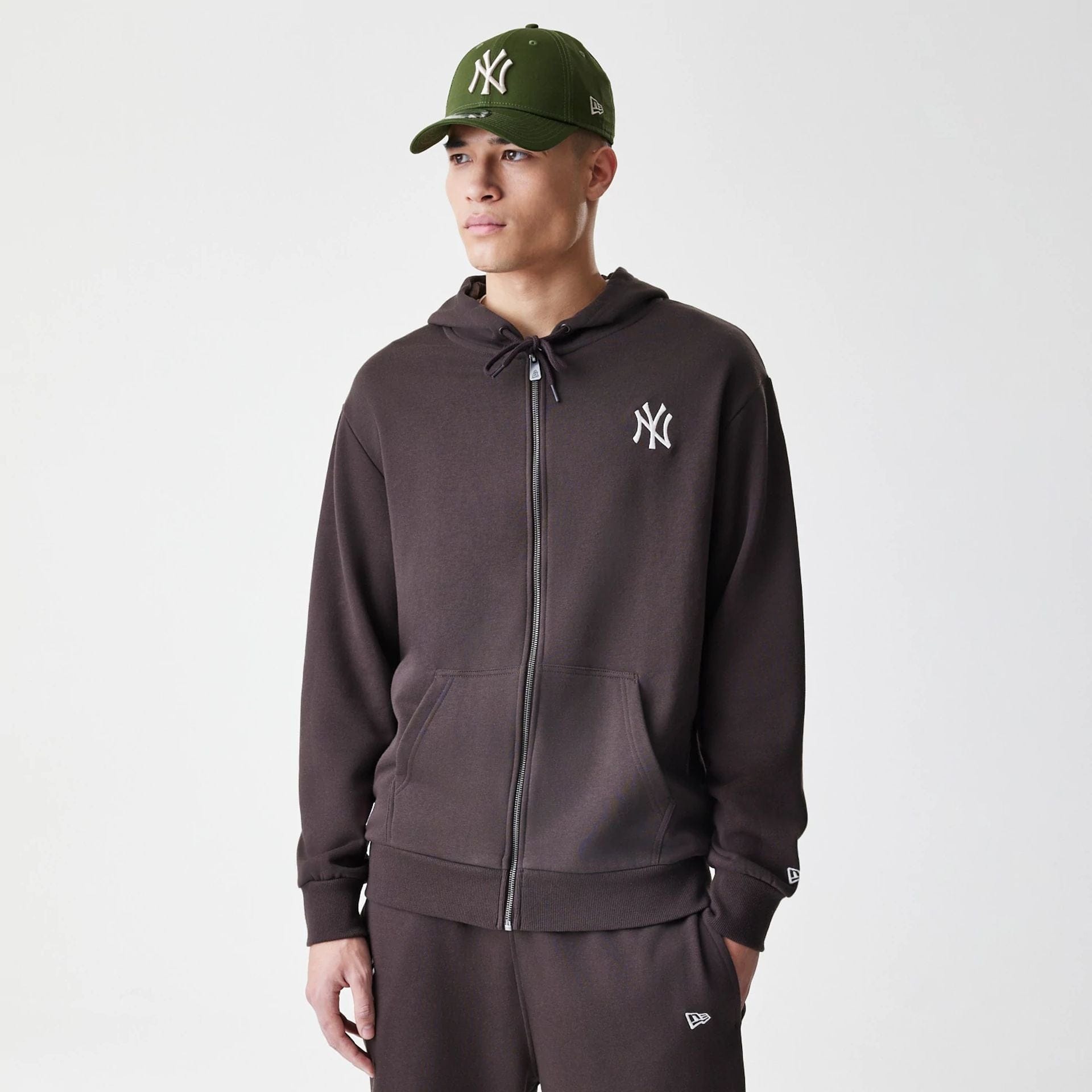 The Male model is wearing New York Yankees MLB Midi League Essential Dark Brown Full Zip Hoodie  1