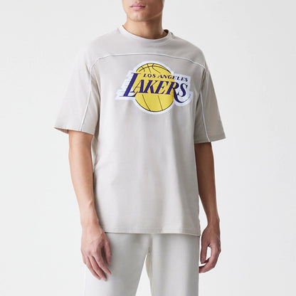 The Male model is wearing LA Lakers NBA Piping Light Beige Oversized T-Shirt  1
