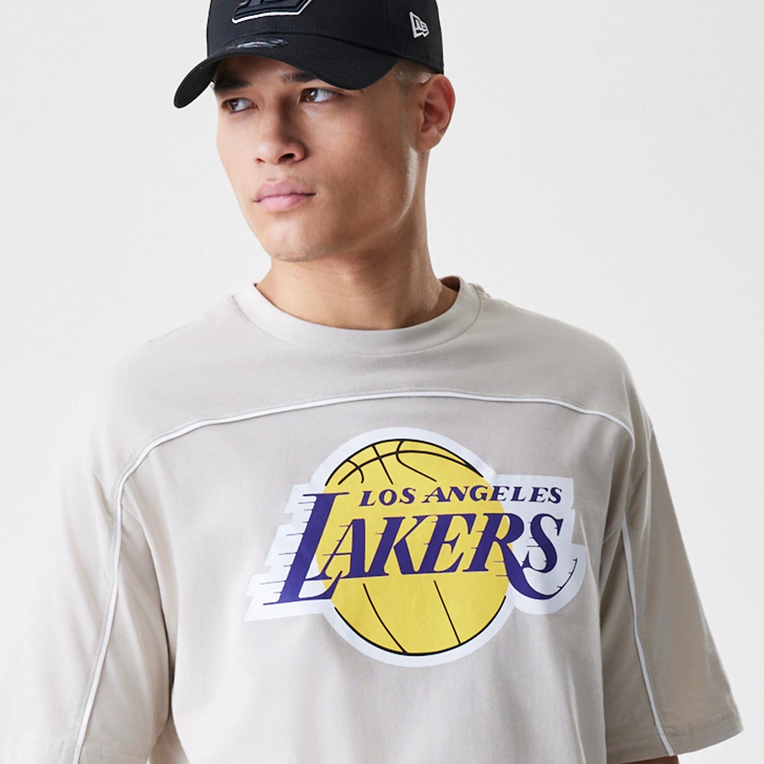 The Male model is wearing LA Lakers NBA Piping Light Beige Oversized T-Shirt 4