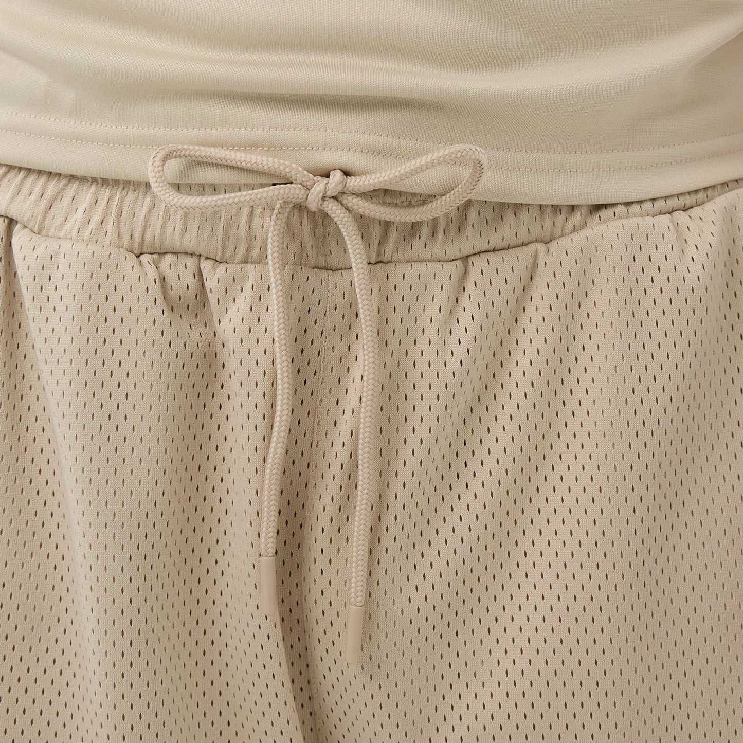 The Male model is wearing New Era Mesh Light Beige Mesh Shorts 5