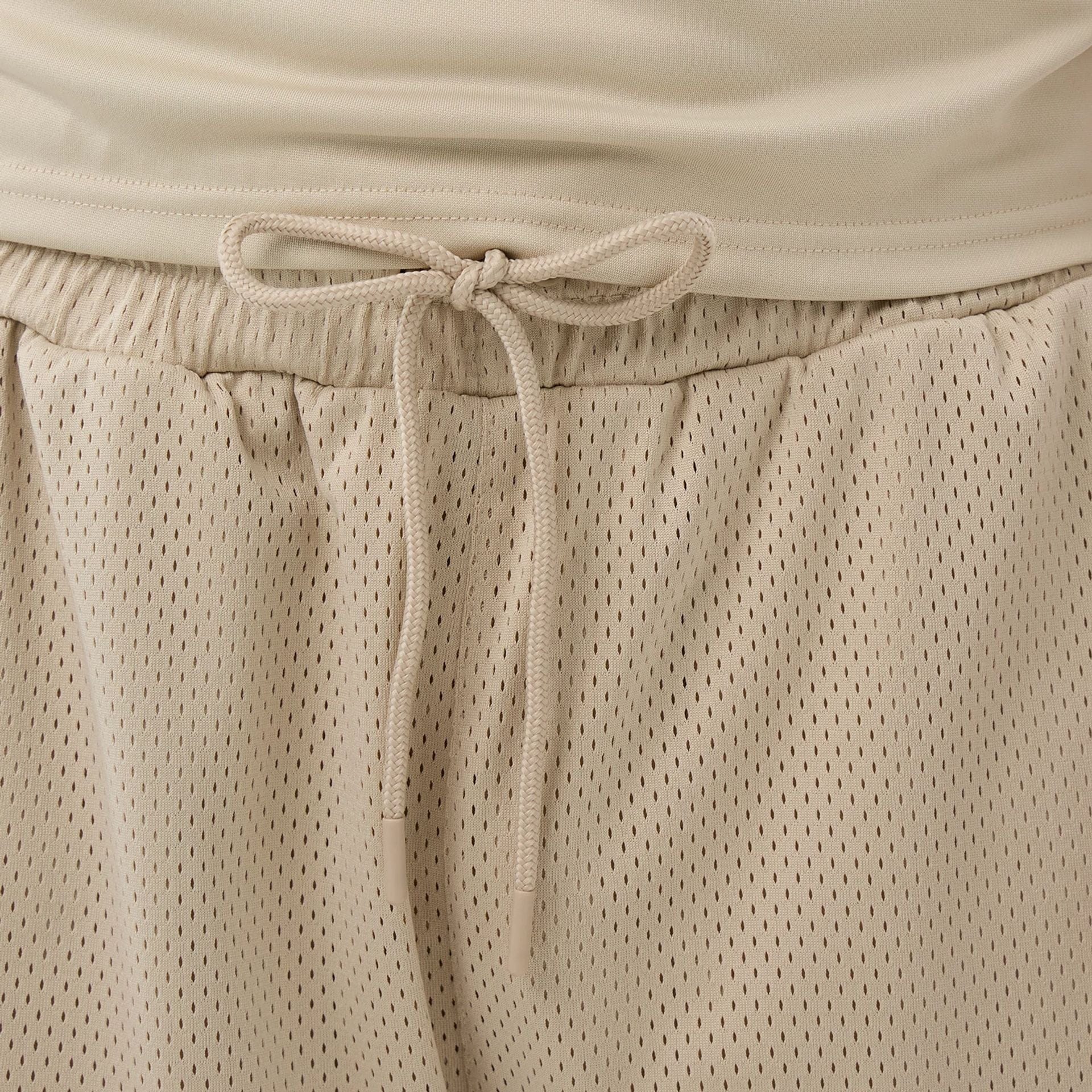 The Male model is wearing New Era Mesh Light Beige Mesh Shorts 5