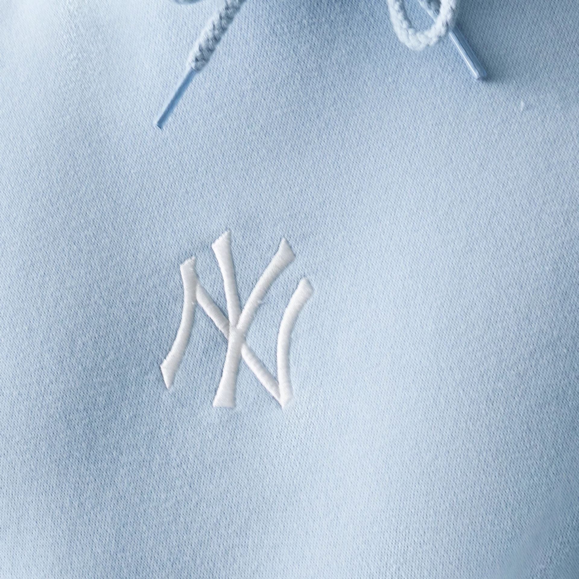 The model is wearing this MLB League Essential Midi New York Yankees Oversized Pullover Hoodie in pastel blue. 6