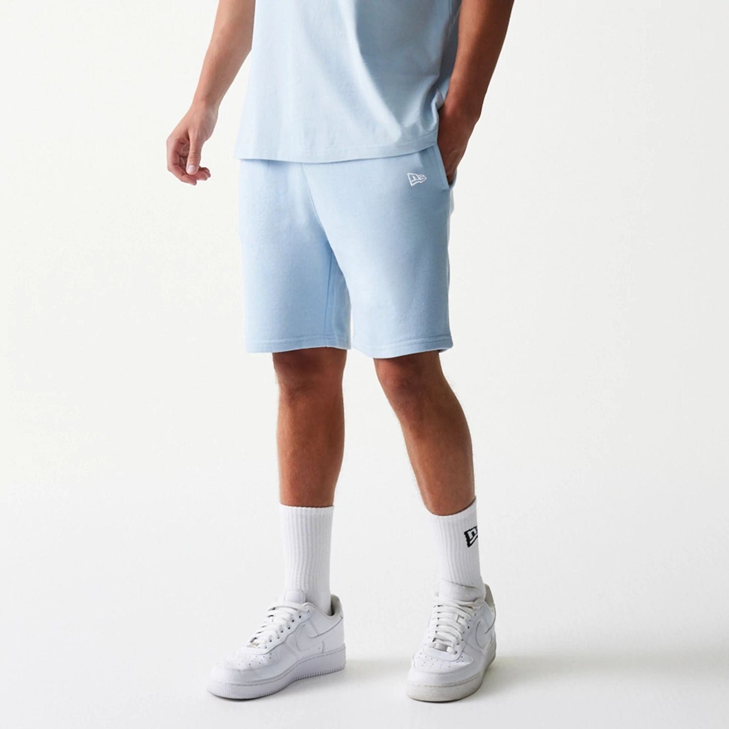 The model is wearing this MLB League Essential Midi New York Yankees Shorts in pastel blue. 1