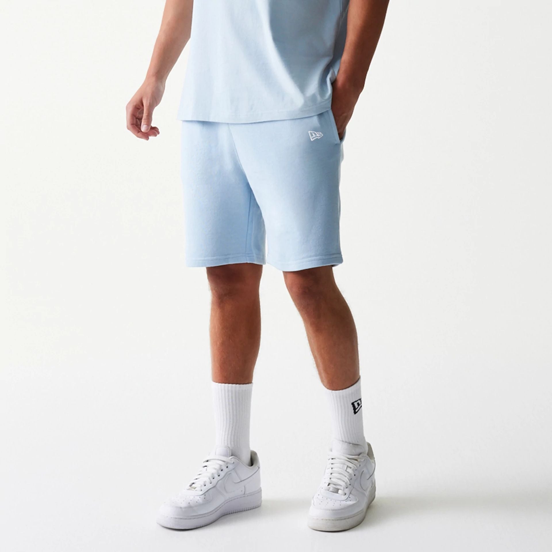 The model is wearing this MLB League Essential Midi New York Yankees Shorts in pastel blue. 1