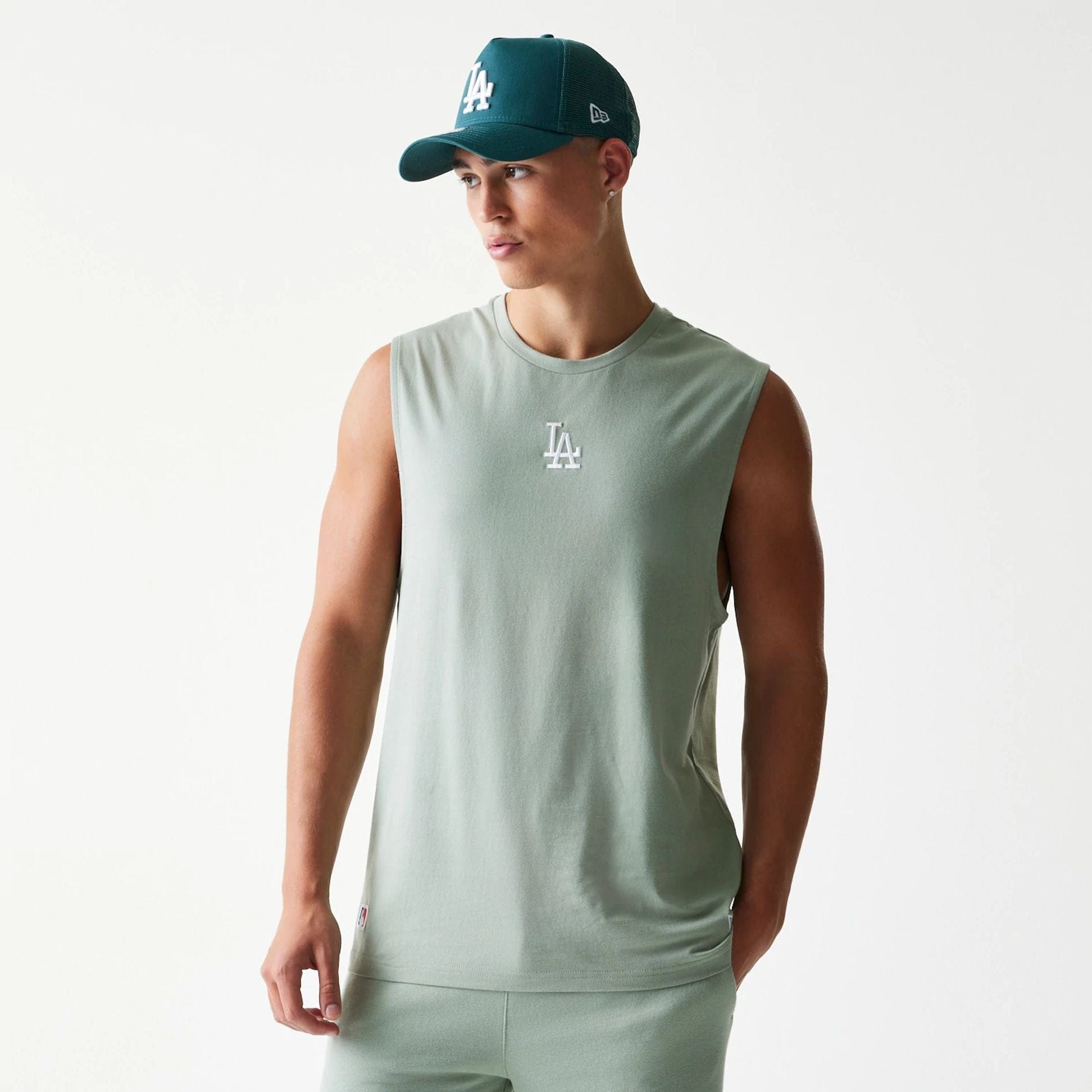 The model is wearing this MLB League Essential LA Dodgers Sleeveless T-Shirt in pastel green. 1
