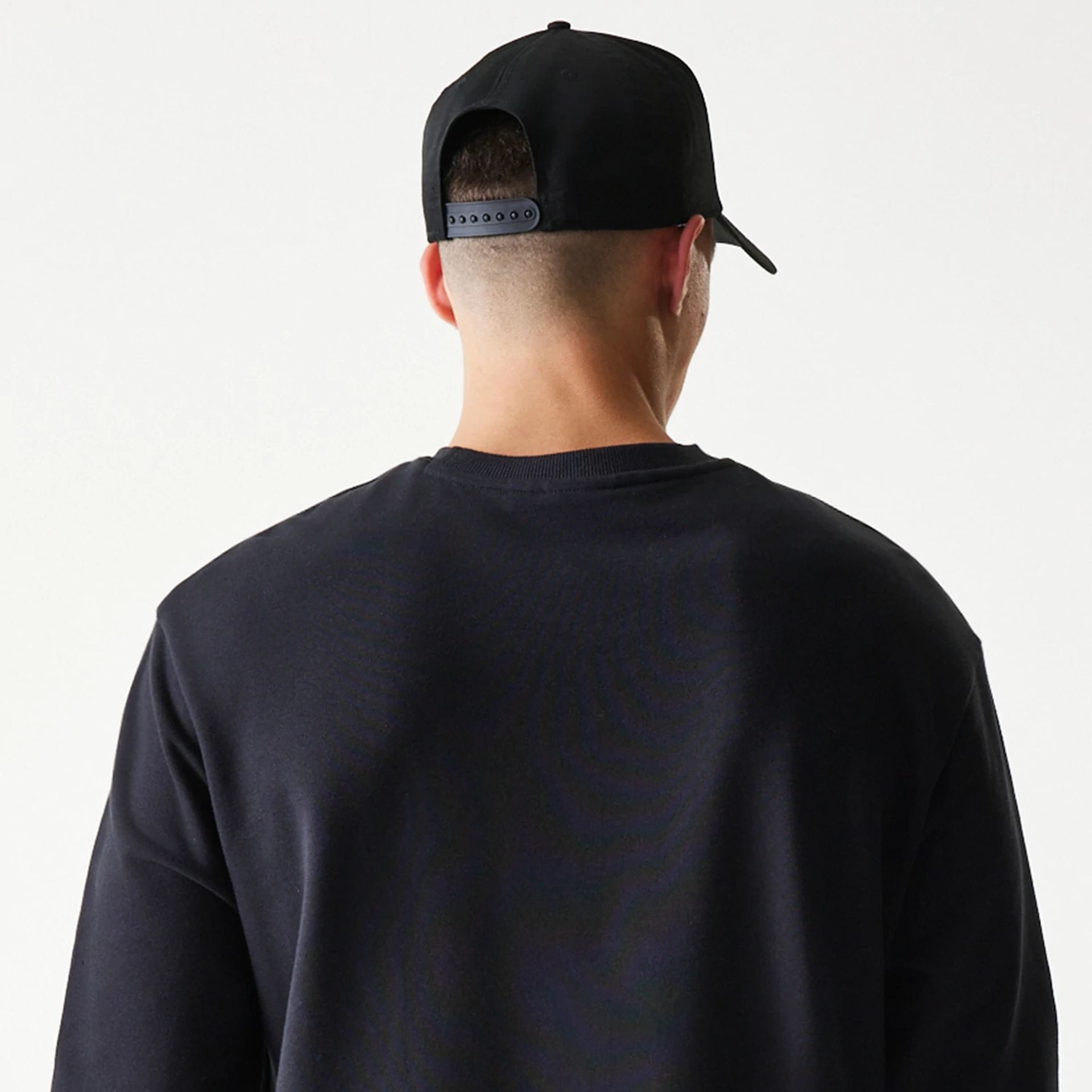 The model is wearing this NBA League Essential Chicago Bulls Oversized Crew Neck Sweater in black. 7