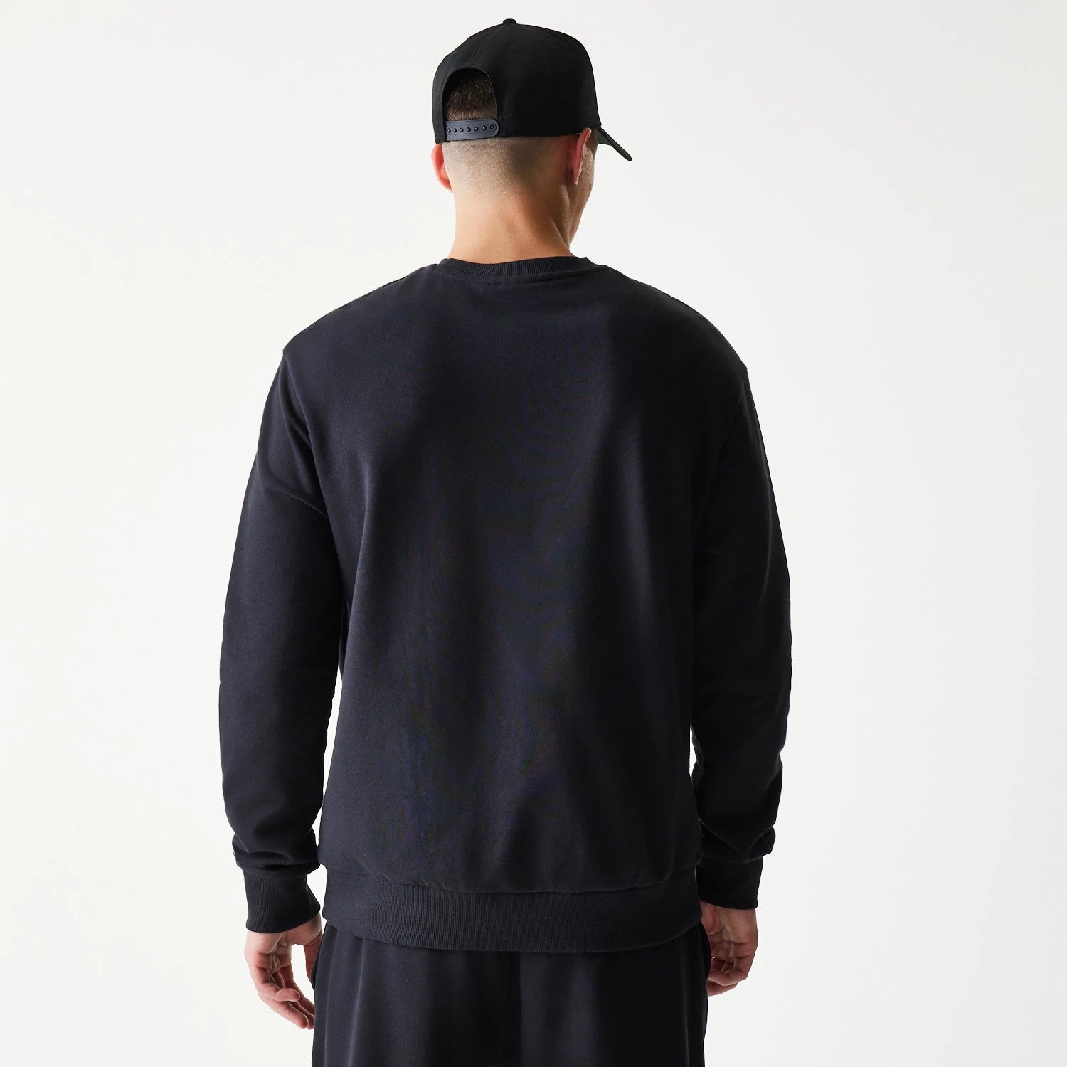 The model is wearing this NBA League Essential Chicago Bulls Oversized Crew Neck Sweater in black. 2