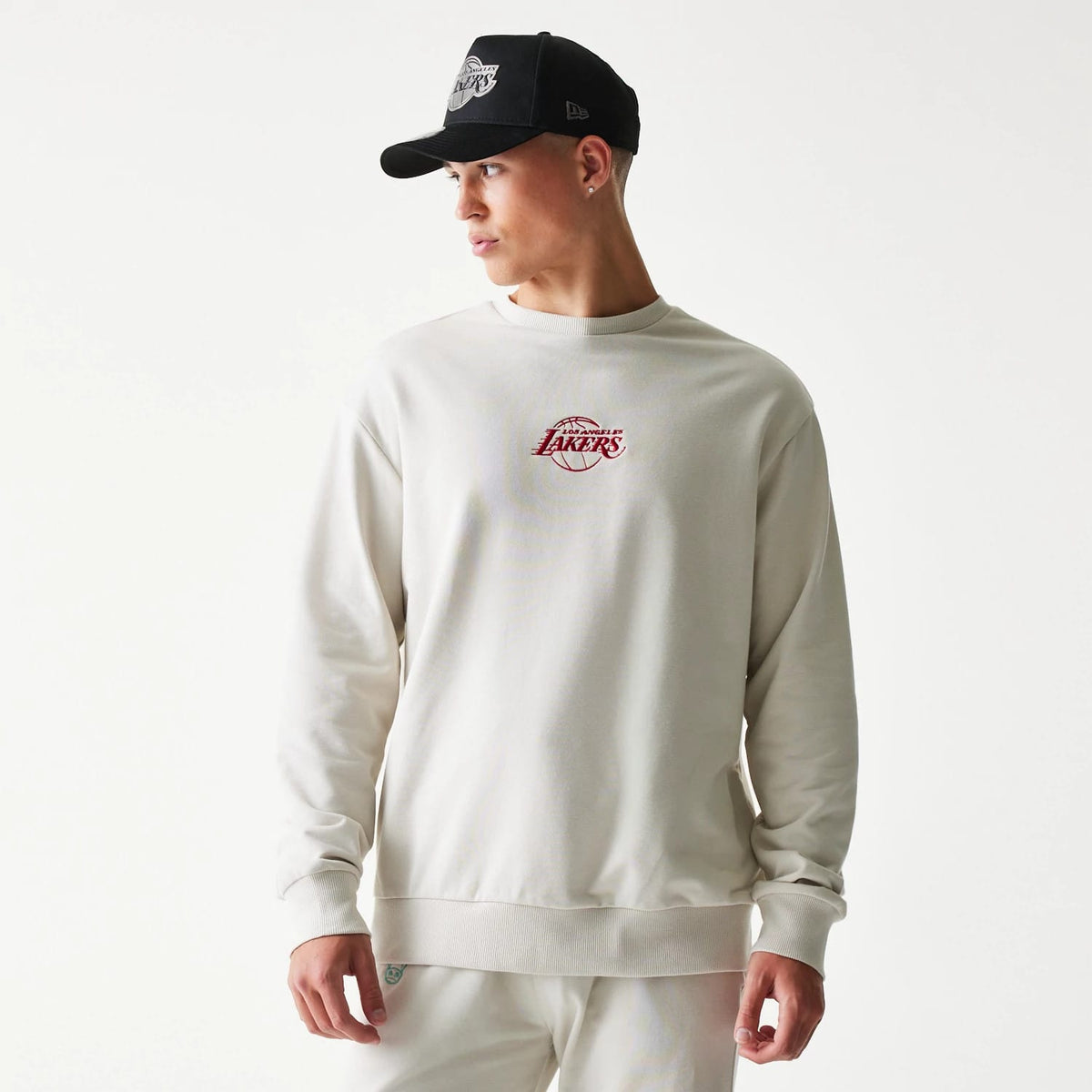 The model is wearing this NBA League Essential LA Lakers Oversized Crew Neck Sweater in cream. 1