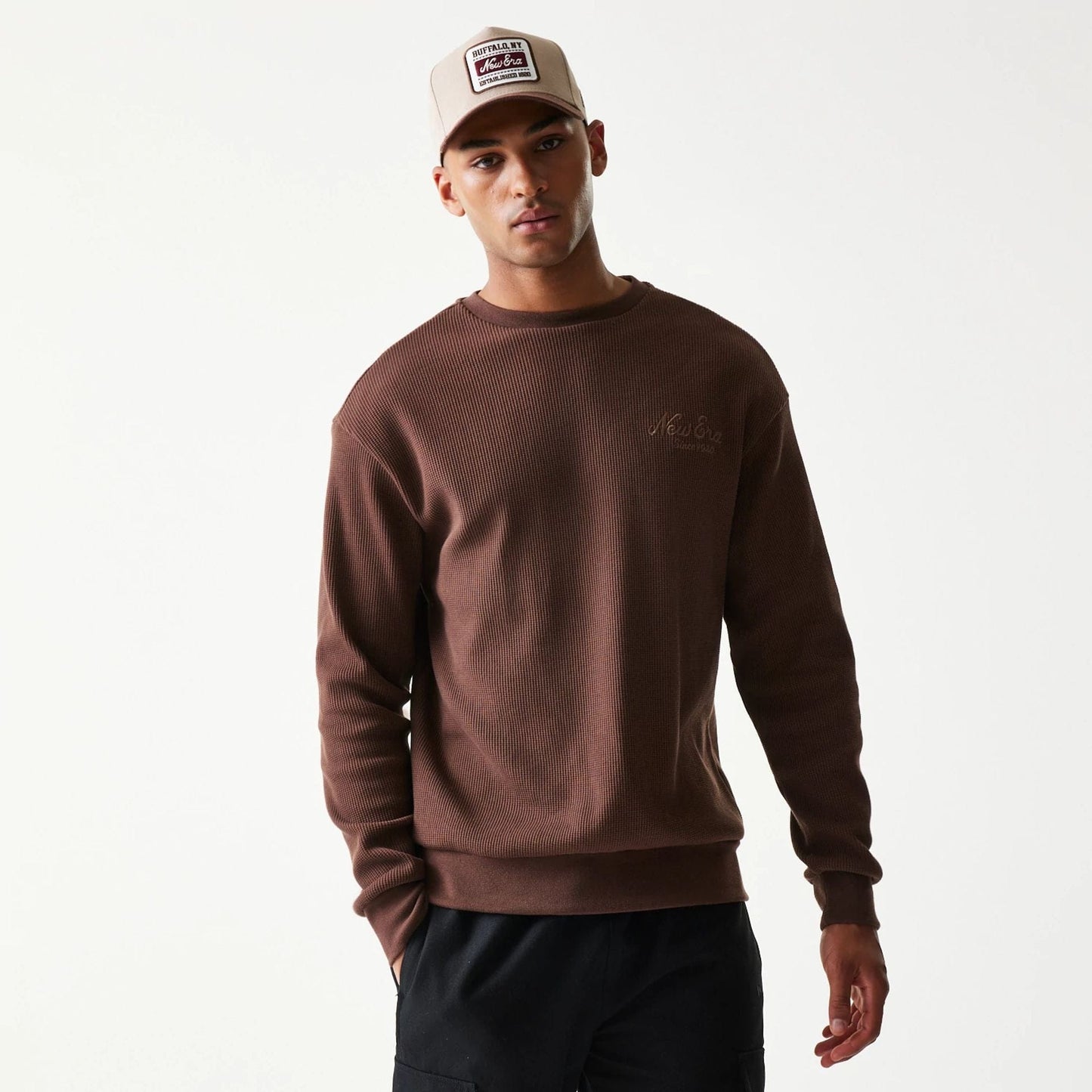 The model is wearing this New Era Script Waffle Crew Neck Sweater in brown. 3