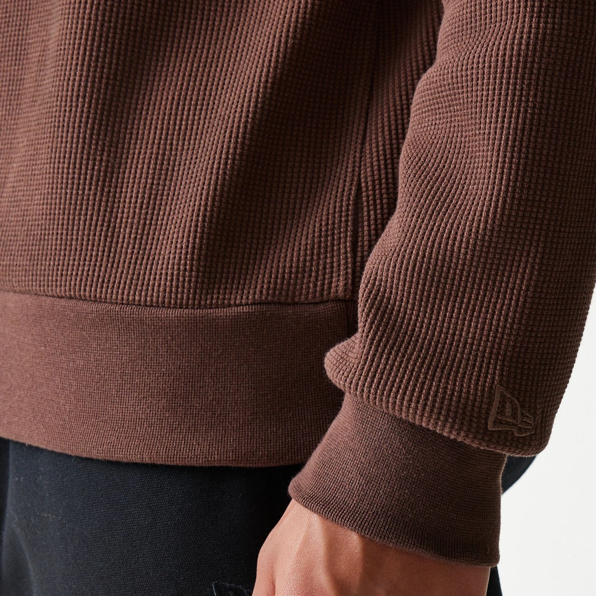 The model is wearing this New Era Script Waffle Crew Neck Sweater in brown. 7