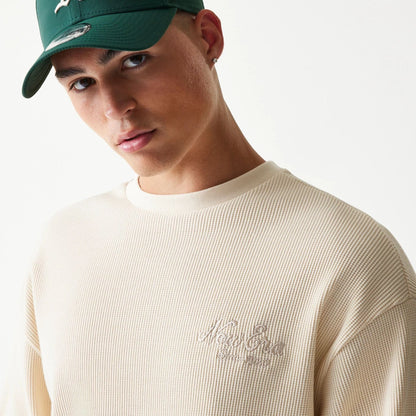 The model is wearing this New Era Script Waffle Crew Neck Sweater in light beige. 5