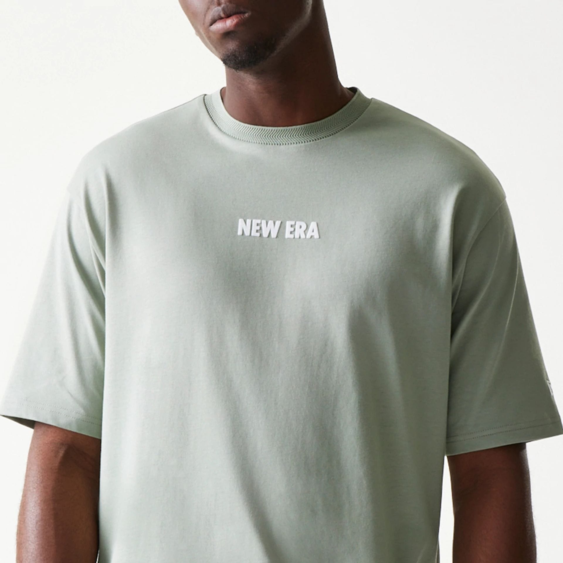 The model is wearing this New Era Graphic Oversized T-Shirt in pastel green. 5