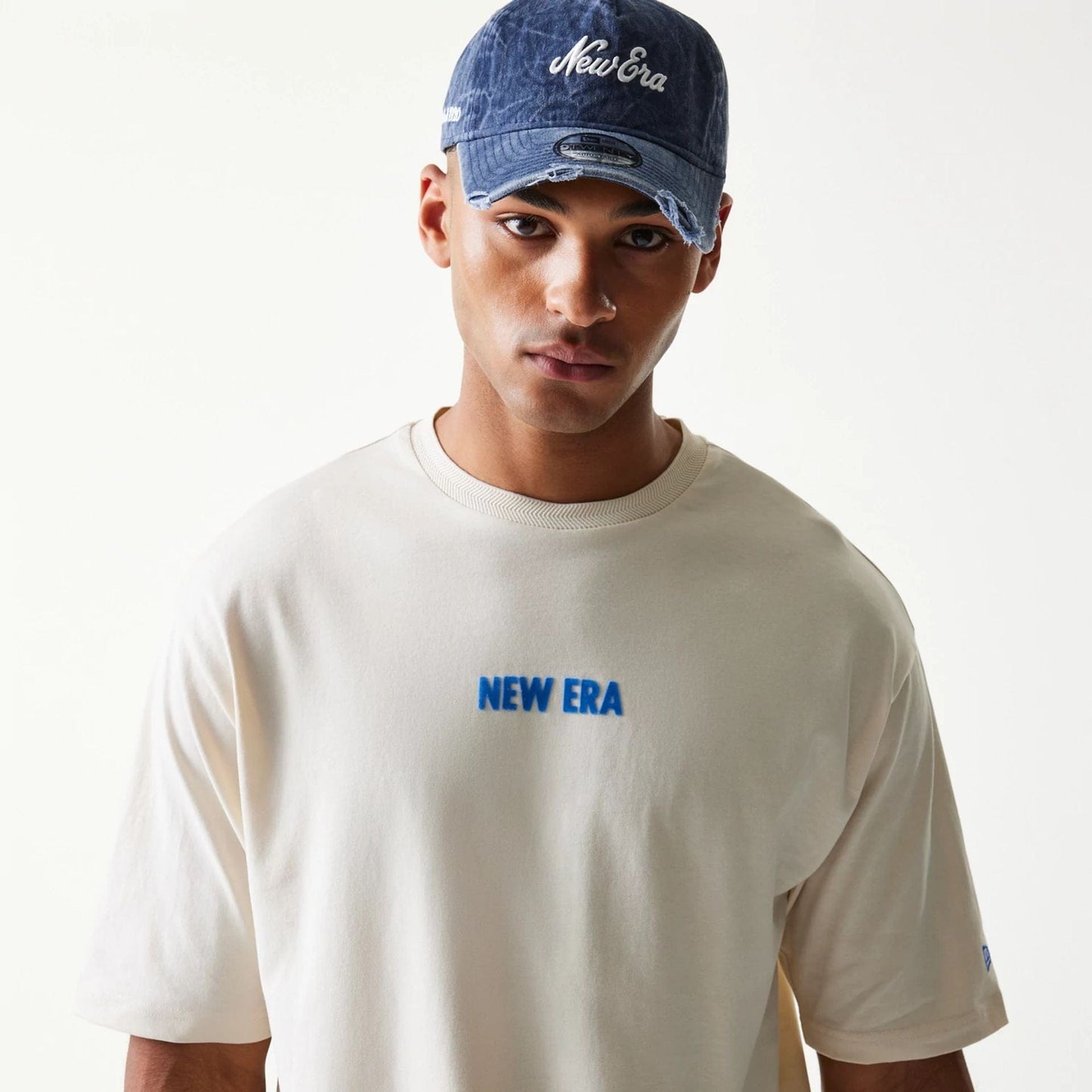 The model is wearing this New Era Graphic Oversized T-Shirt in light beige. 7